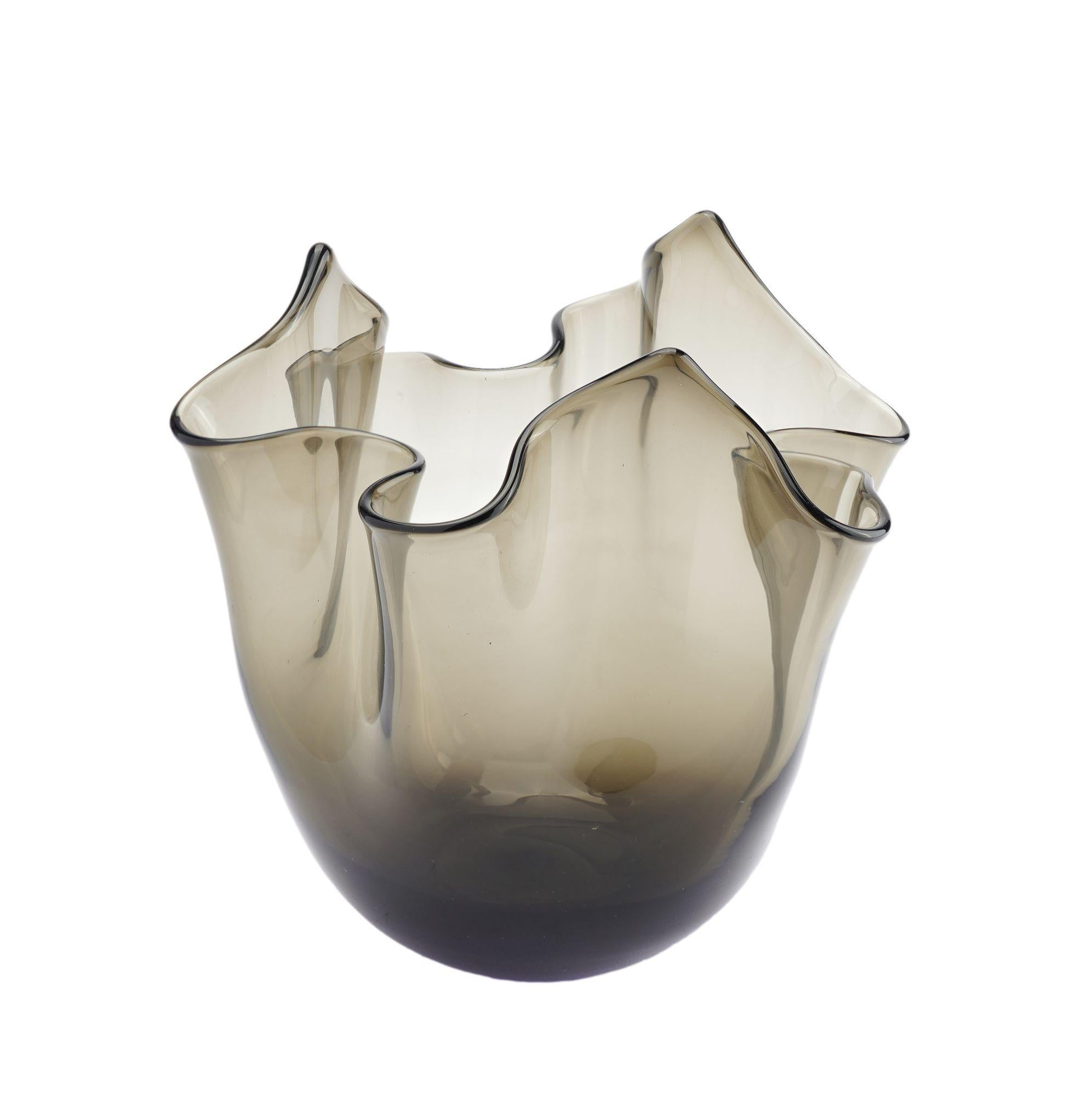 Vaso Fazzoletto non firmato, soffiato a mano, in vetro trasparente grigio fumo con pontile molato e lucidato.

Murano, Italia, metà del XX secolo.