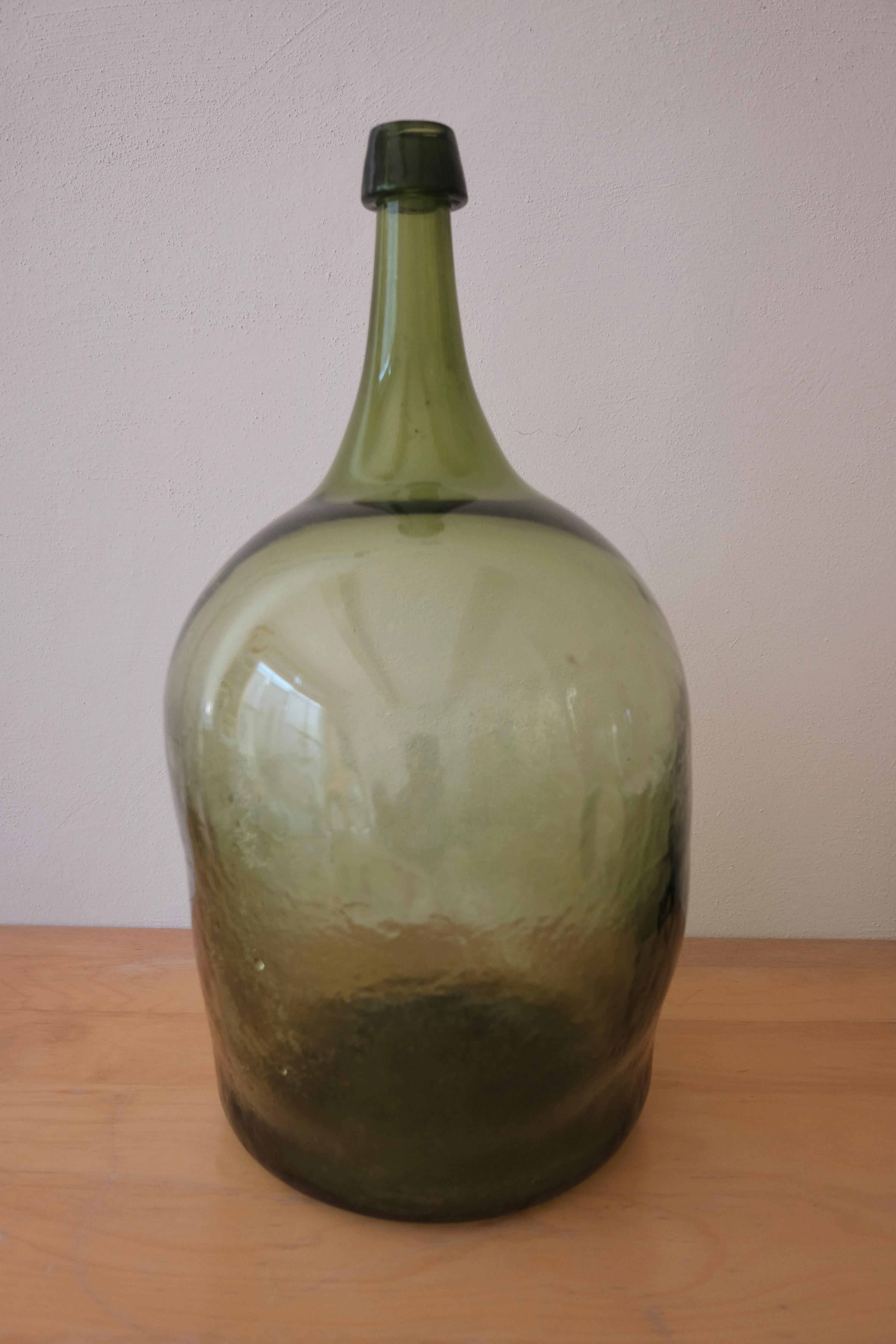 Mouth-blown mezcal demijohn from Veracruz, Mexico. Mineral green color. No mold seams evident throughout the jug, circa 1910-1920.