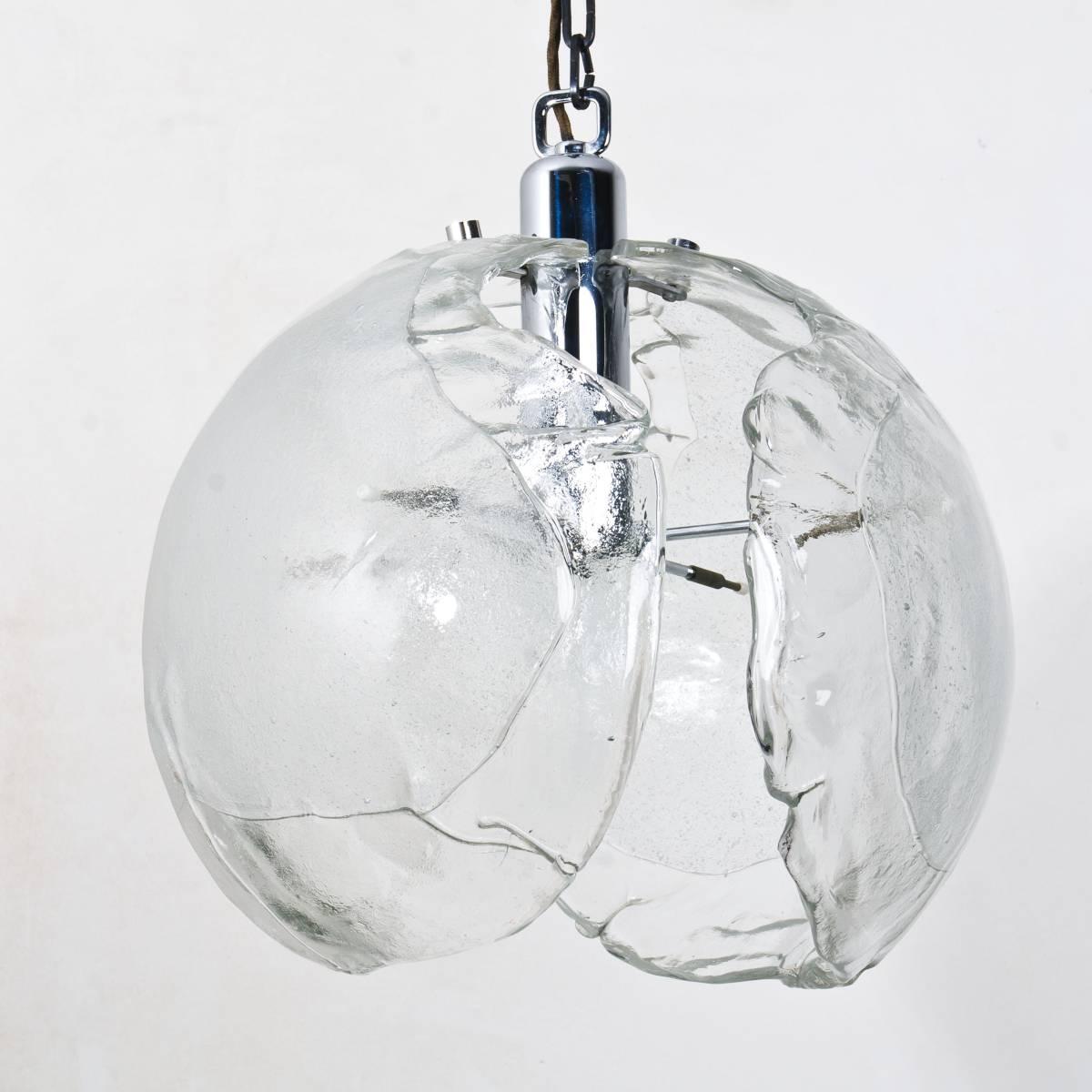 A Mid-Century Modern pendant light, circa 1970, consisting of three very heavy ´petals´ in clear and milk blown glass and brass hardware, this model is often attributed to Carlo Nason but we can´t confirm this at this point. 

Heavy quality and in