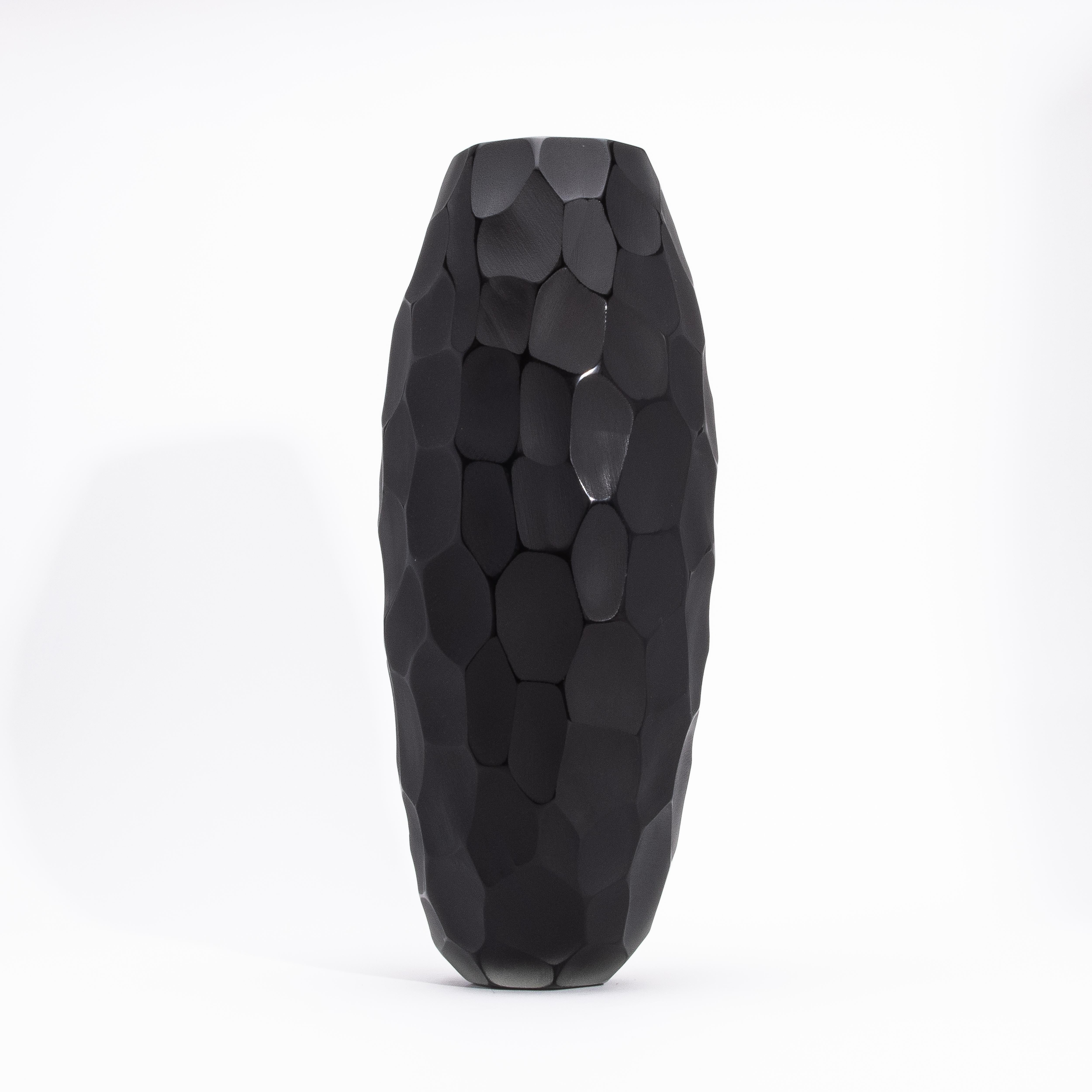 Il Vaso di Murano alto moderno soffiato a mano in nero grande è un capolavoro dell'arte vetraria italiana, realizzato con l'intricata tecnica del Battuto. Questo metodo tradizionale crea un'affascinante texture martellata, dove ogni sfaccettatura