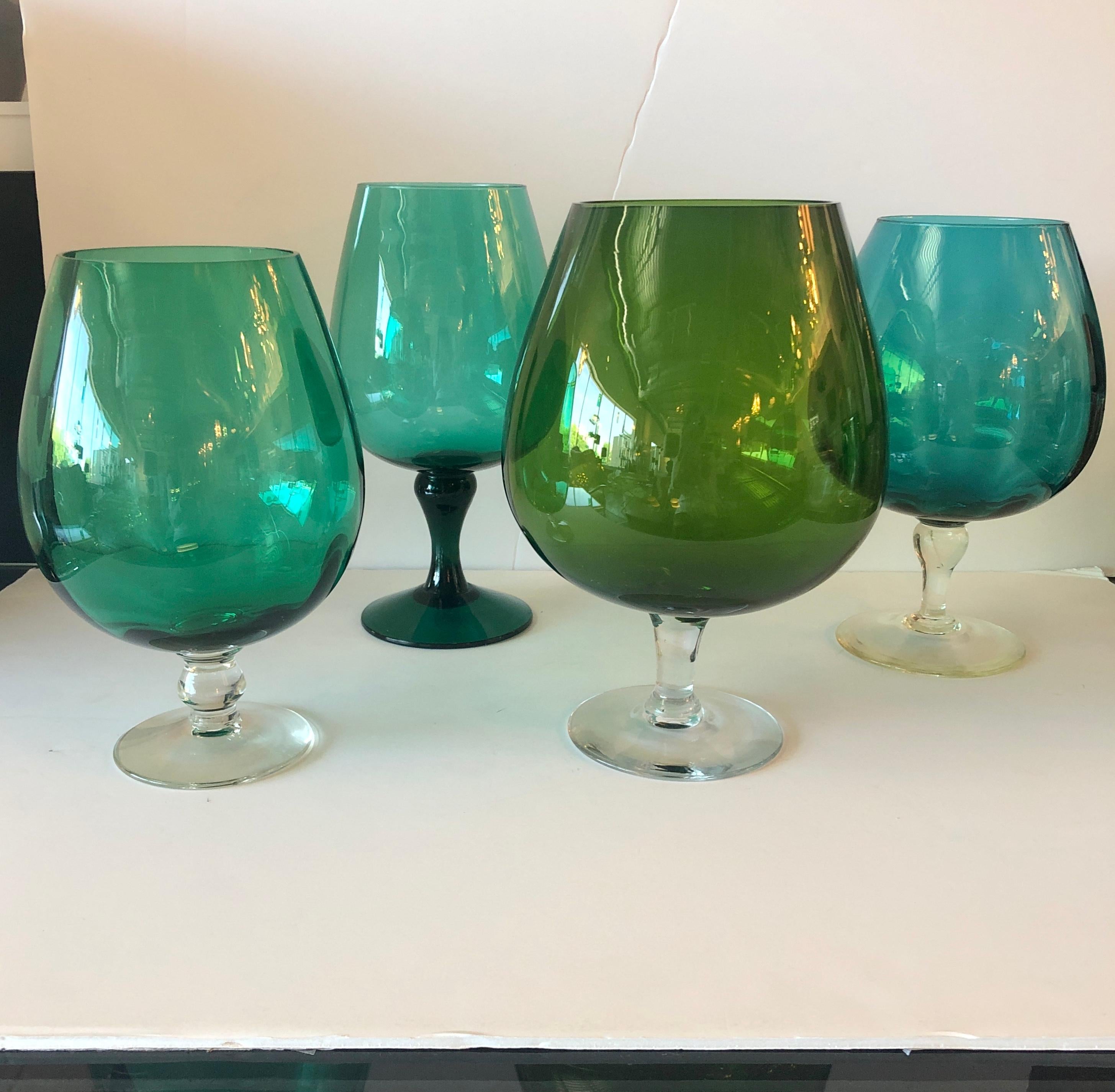 Offered are four Mid-Century Modern hand blown oversized brandy snifters / vases in emerald, teal, peridot (Sold) and Monterey bay green glass with clear glass stems. Would look great as decor, with flowers or on a bar / bar cart. Can be purchased