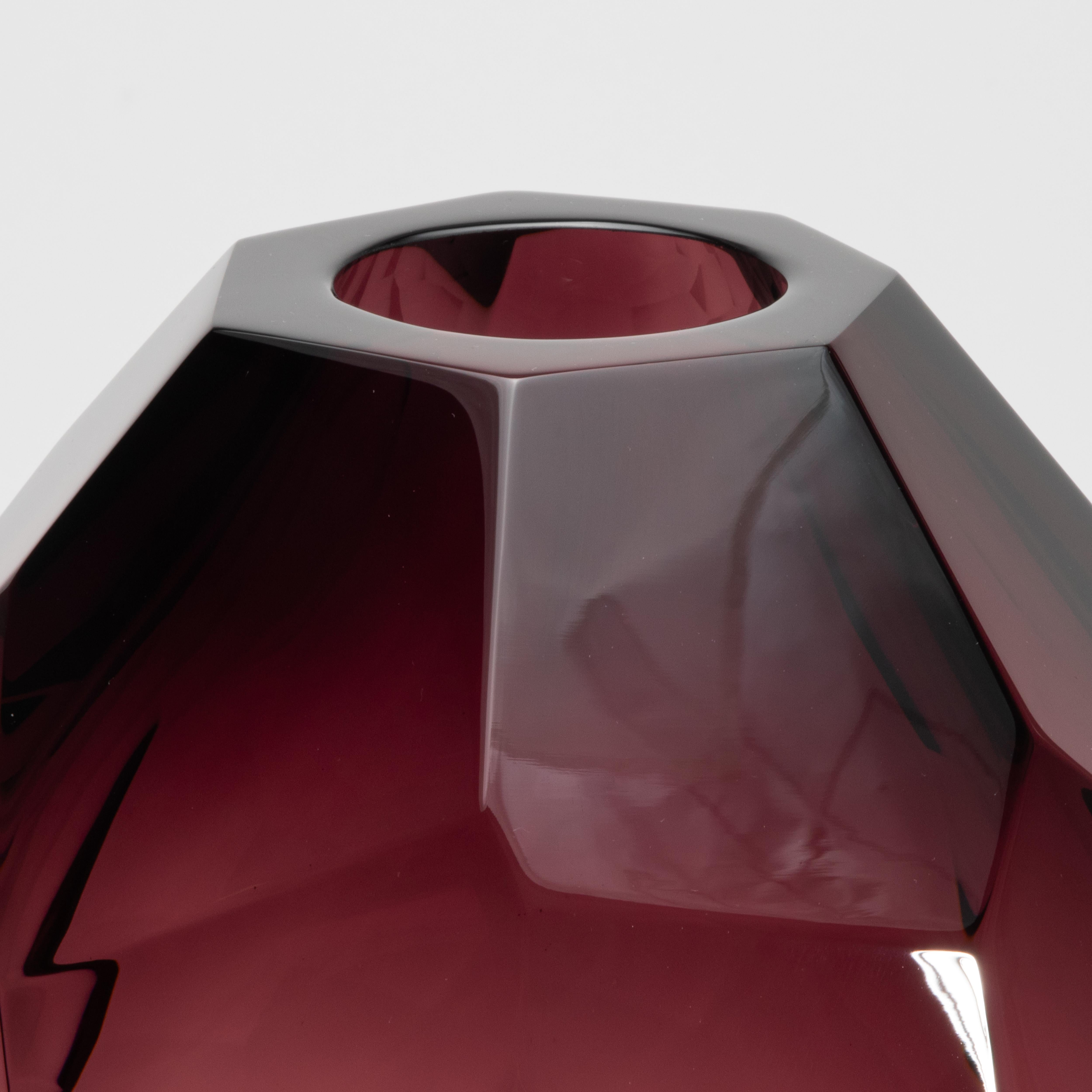 Il vaso a botte di Murano soffiato a mano in ametista affascina con la sua silhouette sfaccettata e la sua presenza architettonica. Realizzato da maestri vetrai, questo pezzo unico è scolpito con precisione simile a un diamante, ogni sfaccettatura è