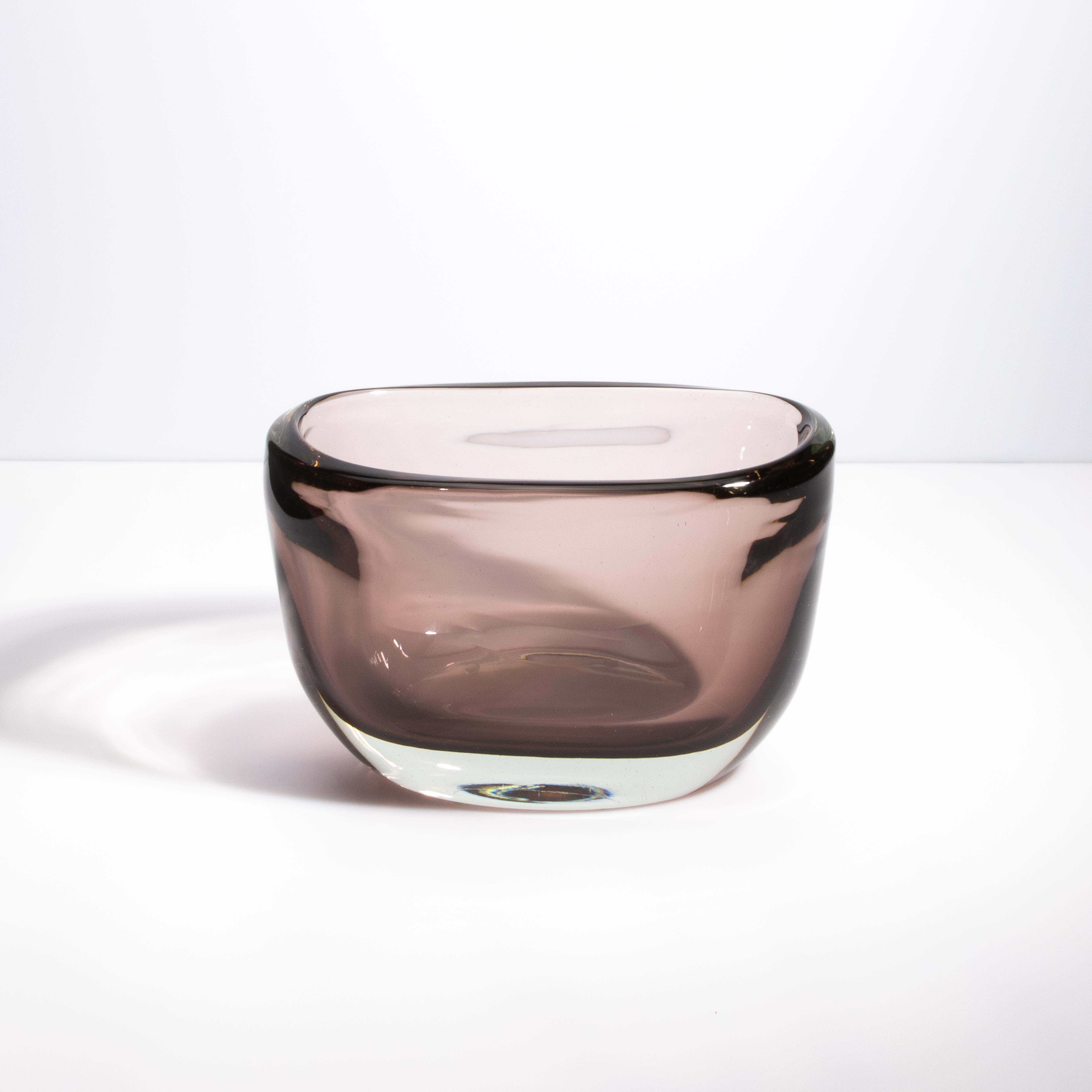 Questo splendido vaso a coppa in vetro di Murano soffiato a mano esemplifica la maestria e l'eleganza per cui i vetrai veneziani sono rinomati. La ciotola presenta un'ipnotica tonalità fumé che irradia raffinatezza e fascino sottile. La sua spessa