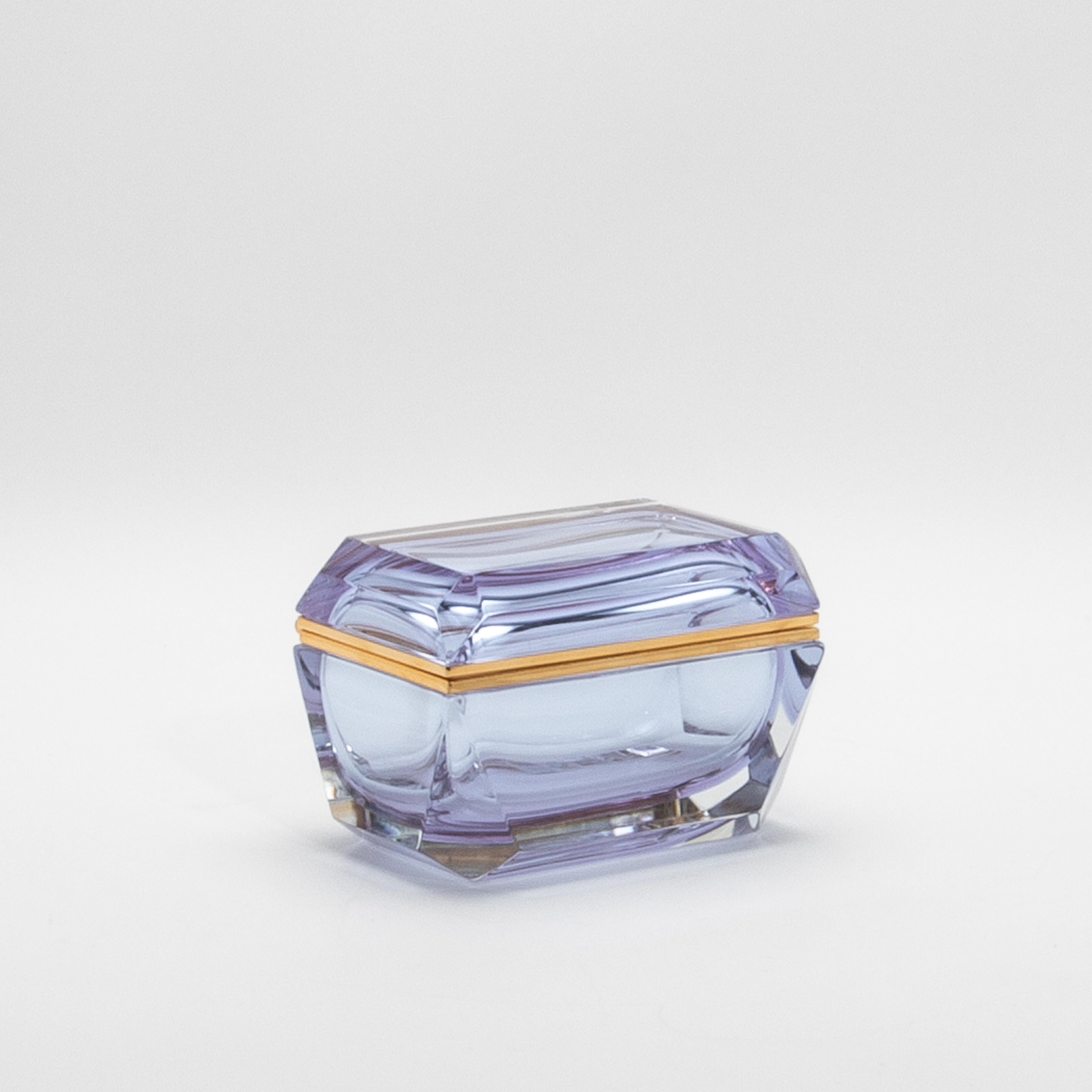 Questo squisito cofanetto in vetro di Murano presenta l'accattivante colore dell'Alessandrite, rinomato per le sue incantevoli proprietà di cambiare colore. Le ricche tonalità del vetro cambiano meravigliosamente sotto diverse luci, passando dal