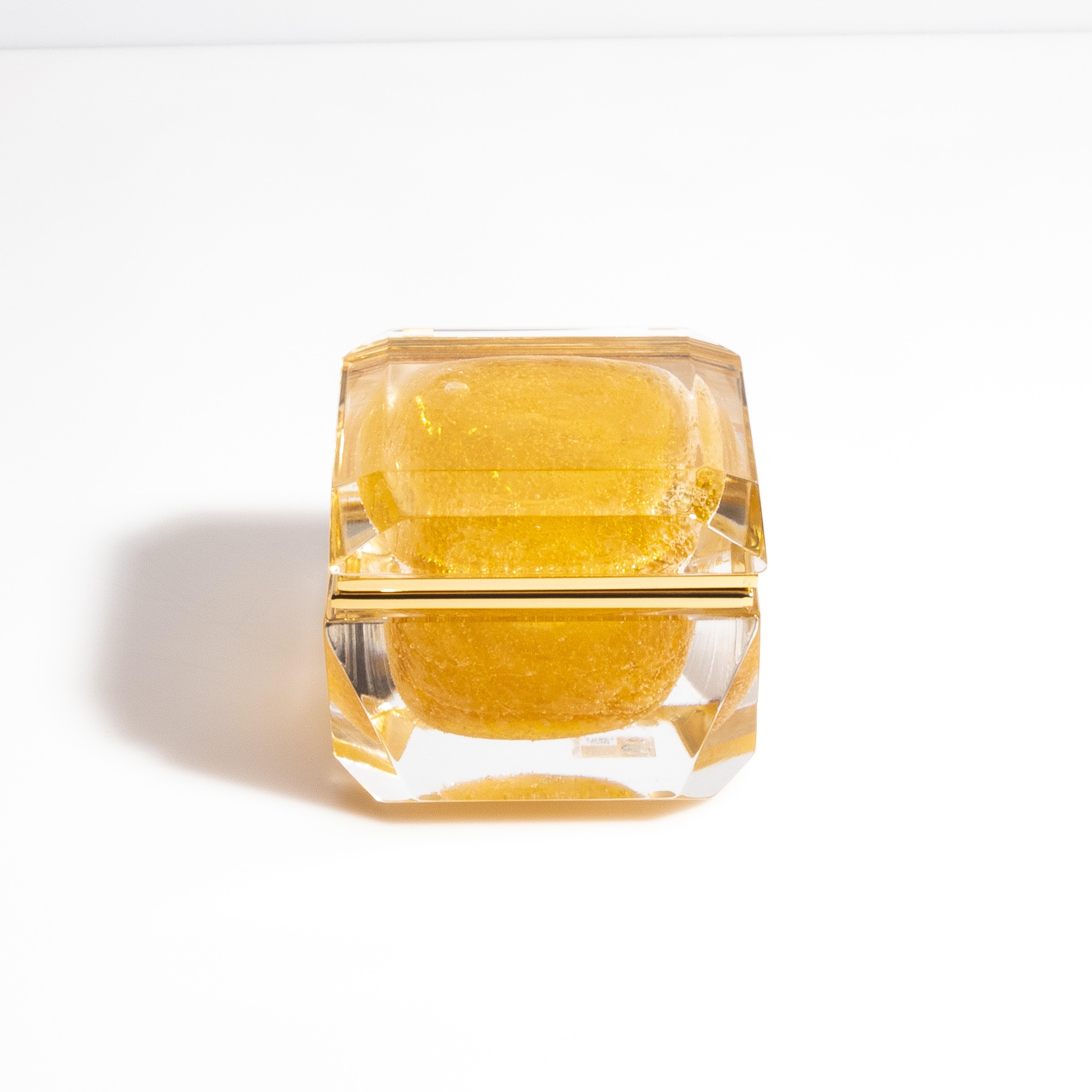 Questo squisito cofanetto in vetro di Murano presenta un lussuoso colore ambrato che irradia calore e raffinatezza. Il pezzo è meticolosamente realizzato a mano da maestri artigiani di Murano, in Italia, e mostra un perfetto mix di artigianato