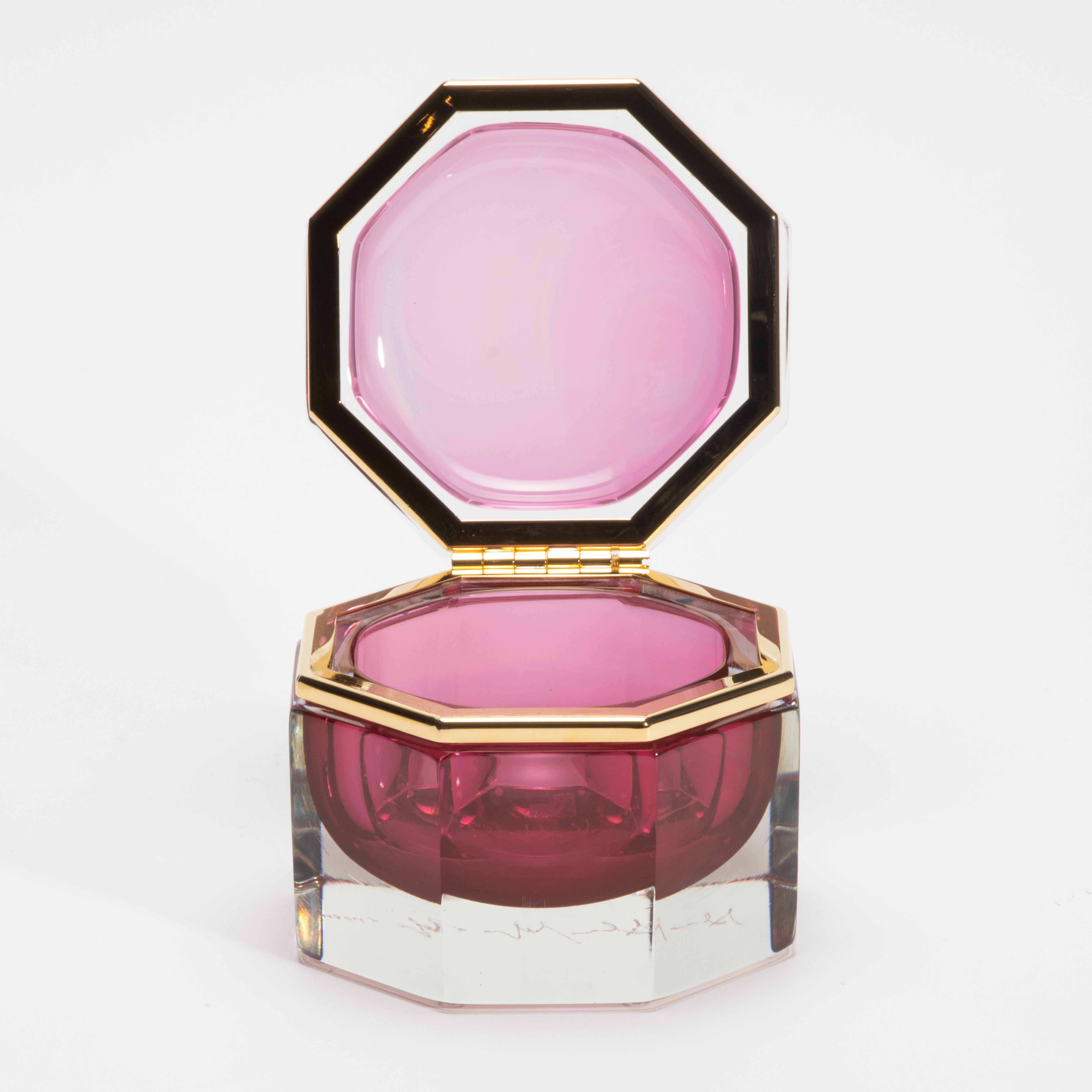 La boîte Murano soufflée à la main en rubis avec des accessoires en laiton est un objet d'art semblable à un bijou, conçu pour captiver par son opulente radiance et sa silhouette moderne. Fabriquée en Italie par des maîtres verriers, cette pièce