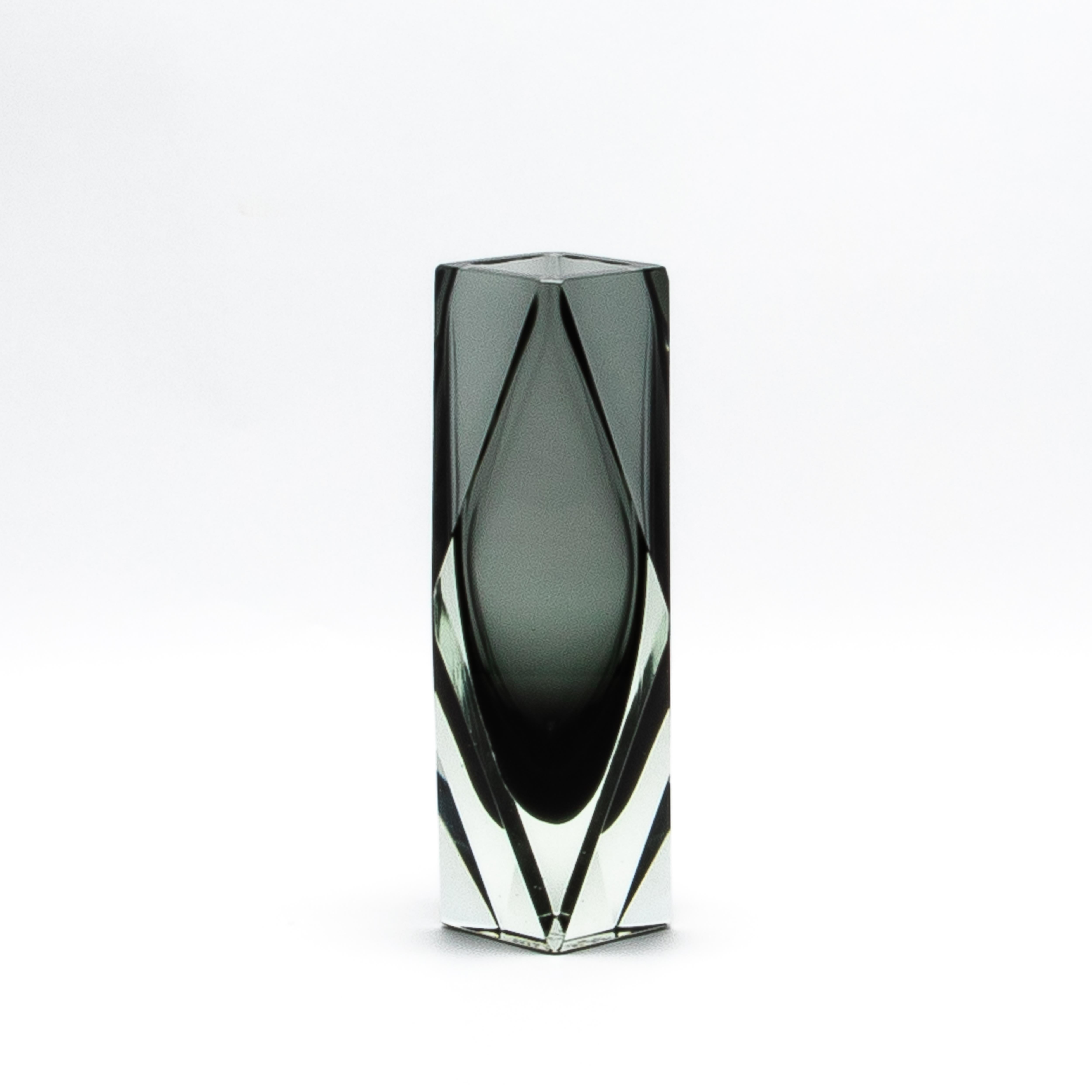 Il Vaso Briolette di Murano soffiato a mano in grigio è una splendida testimonianza di raffinato artigianato. Progettato con precisione, questo capolavoro geometrico presenta linee pulite e angolari che creano un aspetto sfaccettato che ricorda una