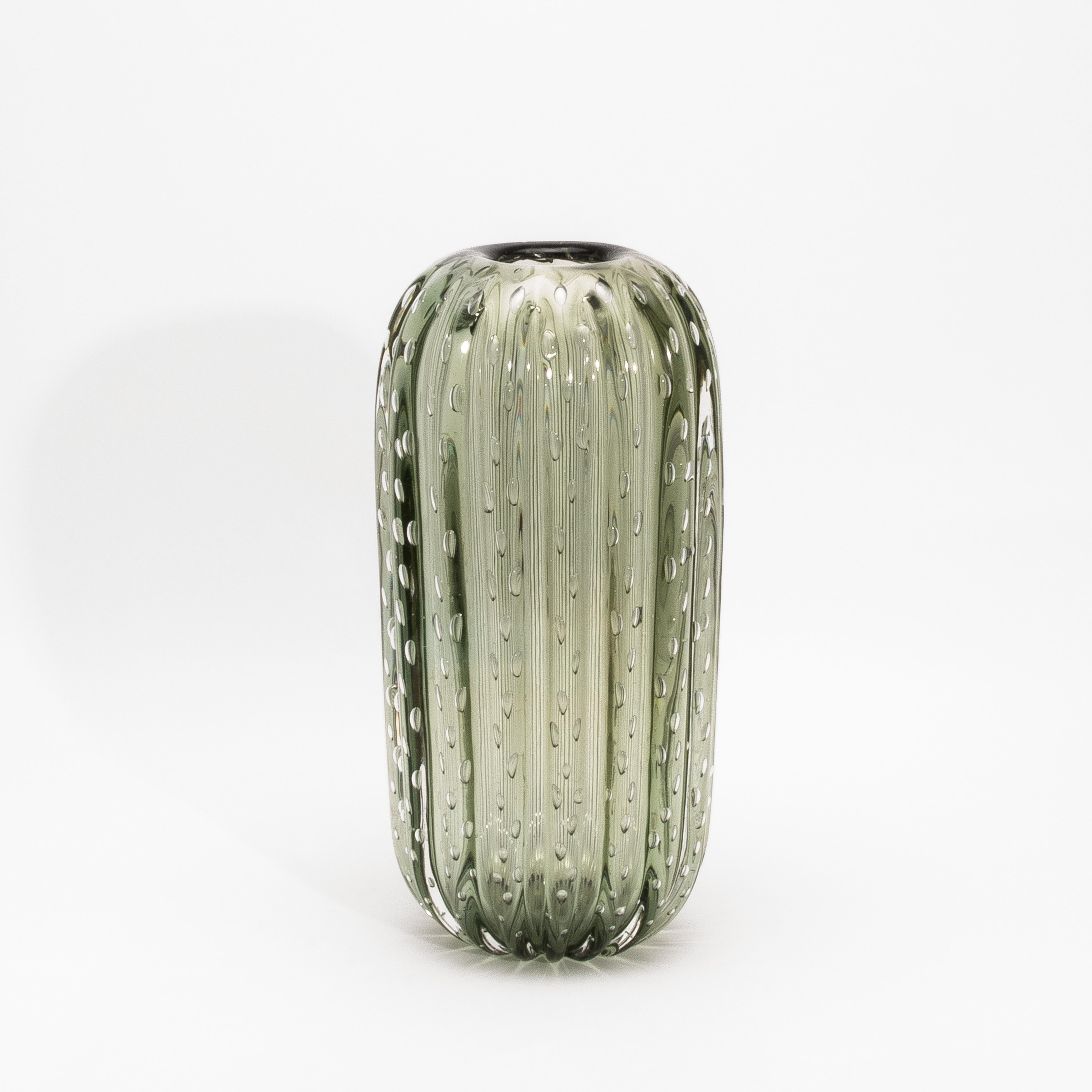 Fusion saisissante de formes organiques et de maîtrise vénitienne, ce vase à cactus de Murano soufflé à la main en vert fougère avec bulles rayonne de poésie tactile et de grâce sculpturale. Son corps légèrement nervuré, inspiré des courbes