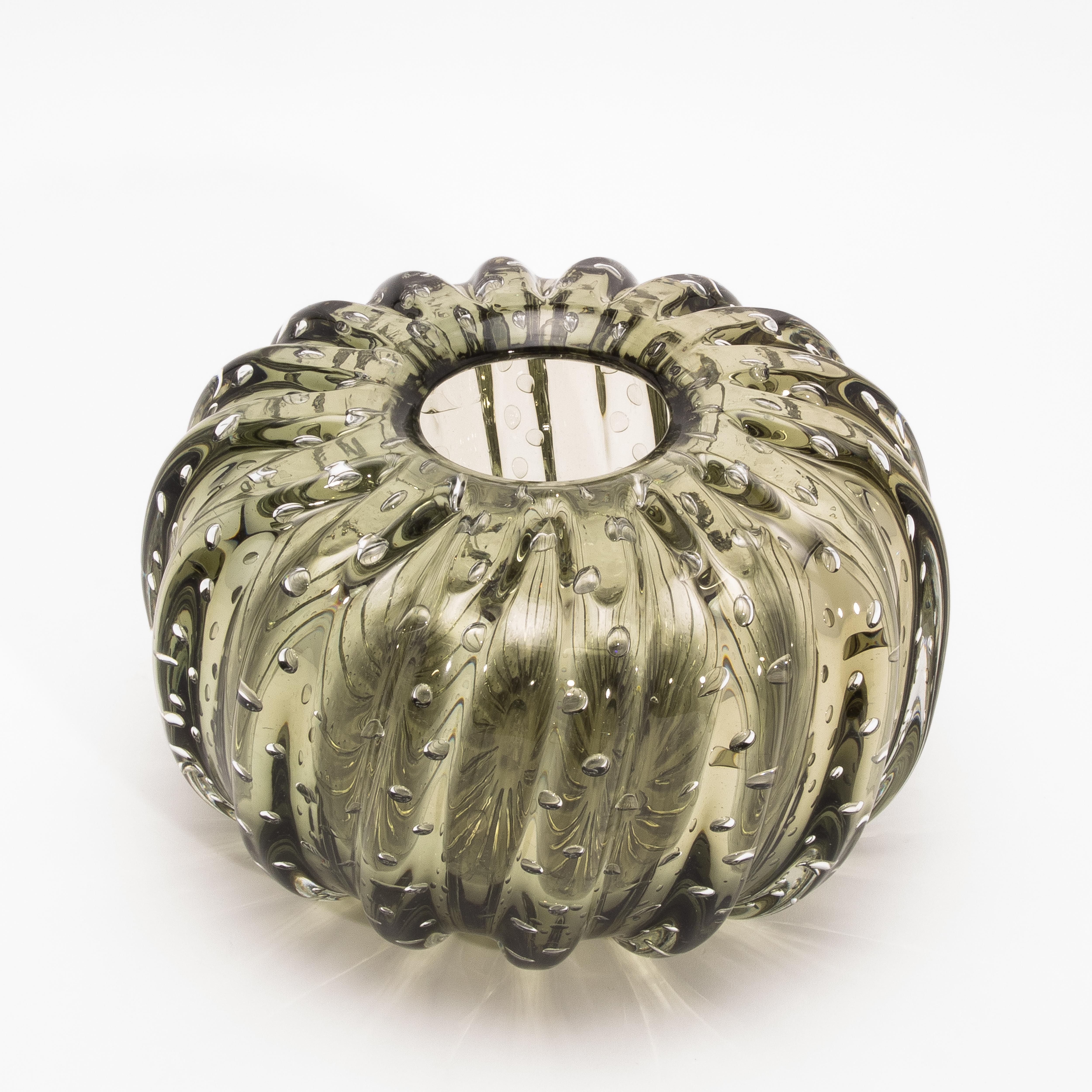 Una straordinaria fusione di forme organiche e maestria veneziana: questo vaso di Murano soffiato a mano in Greene & Greene con bolle irradia poesia tattile e grazia scultorea. Il suo corpo a coste, ispirato alle curve voluttuose della flora del