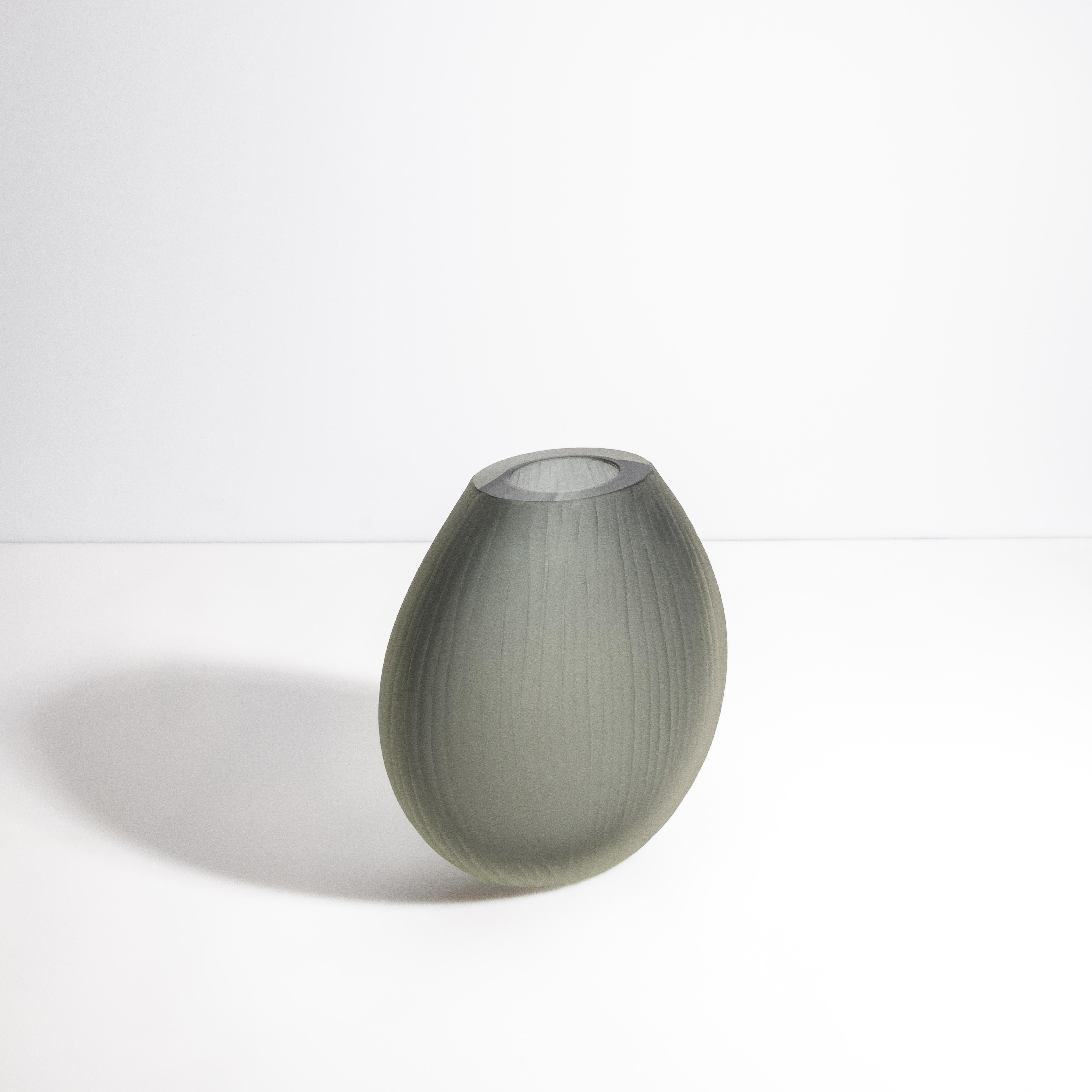 Questo vaso di Murano emana un'aura di lusso raffinato e di moderna eleganza. La finitura grigia opaca, accentuata da una texture a coste, crea un'esperienza visiva e tattile sofisticata e sobria. Le sottili nervature esaltano la profondità e la