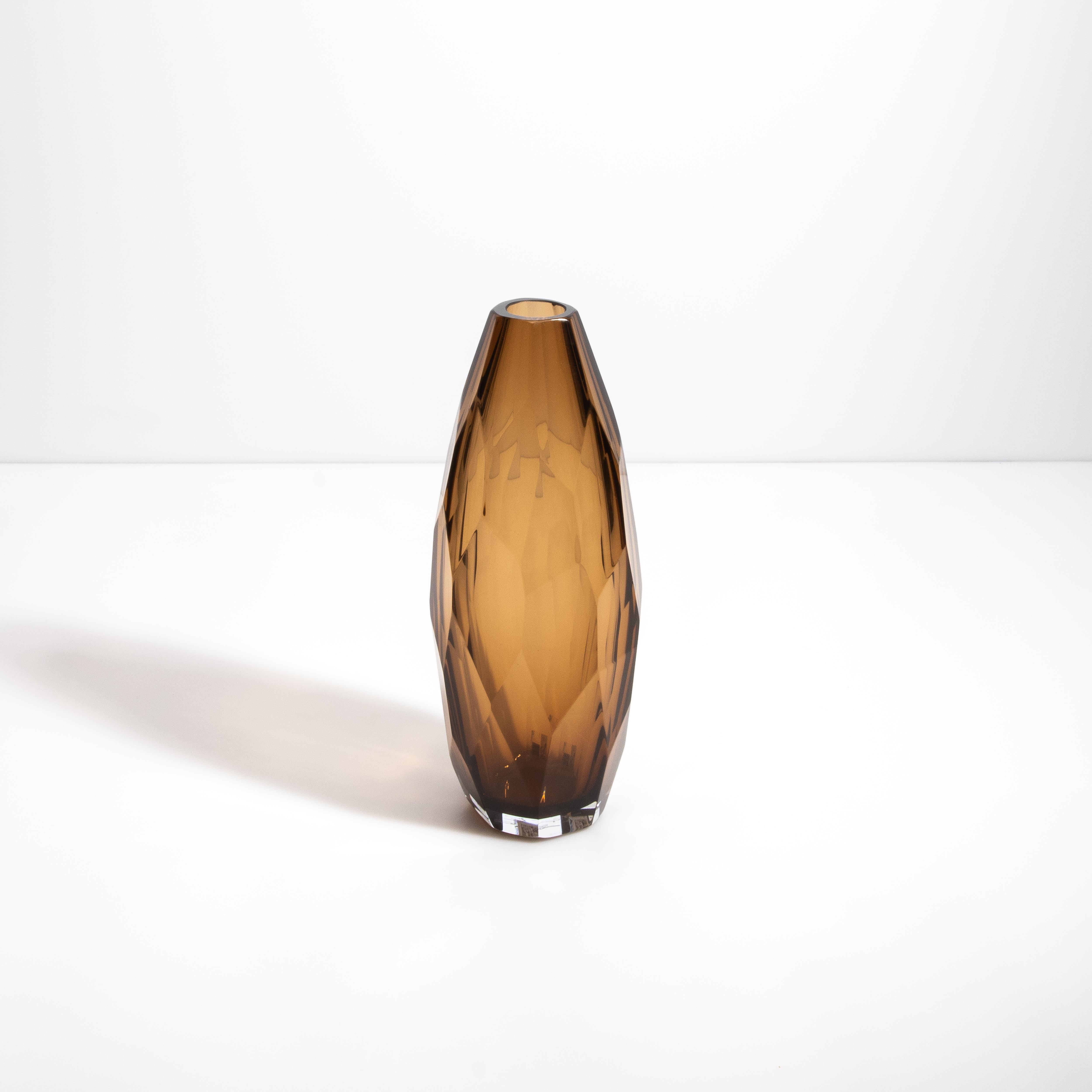 Eleva tu decoración interior con este exquisito jarrón en un sofisticado tono tabaco. Esta magistral creación encarna la cumbre del arte del cristal italiano, donde la tradición se une a la modernidad. Cada superficie cuidadosamente facetada