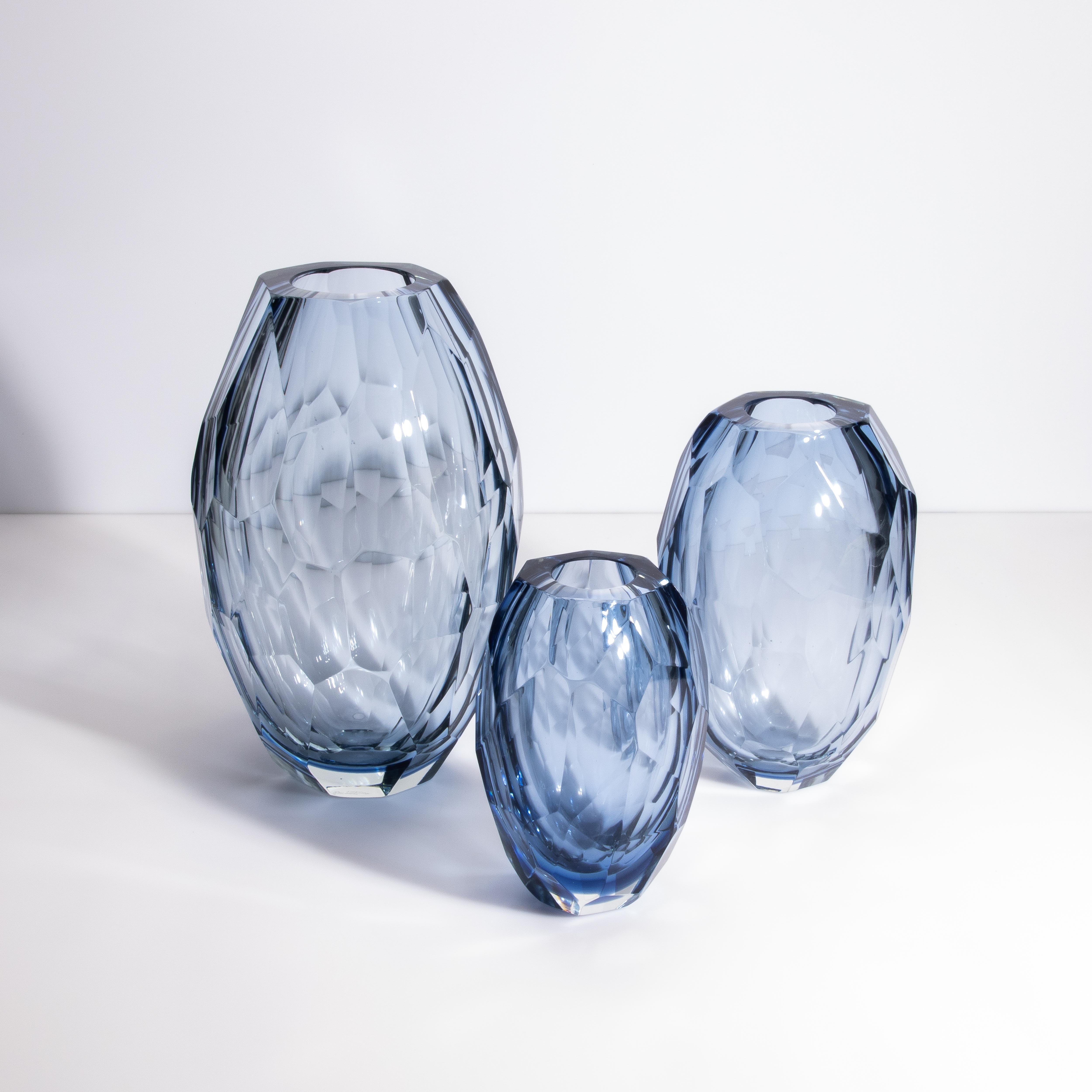 Voici un superbe trio de vases en verre de Murano, chacun étant un chef-d'œuvre de l'artisanat vénitien. Ces vases, soufflés à la main par les artisans qualifiés de Murano, présentent un design à facettes qui crée un captivant jeu d'ombre et de