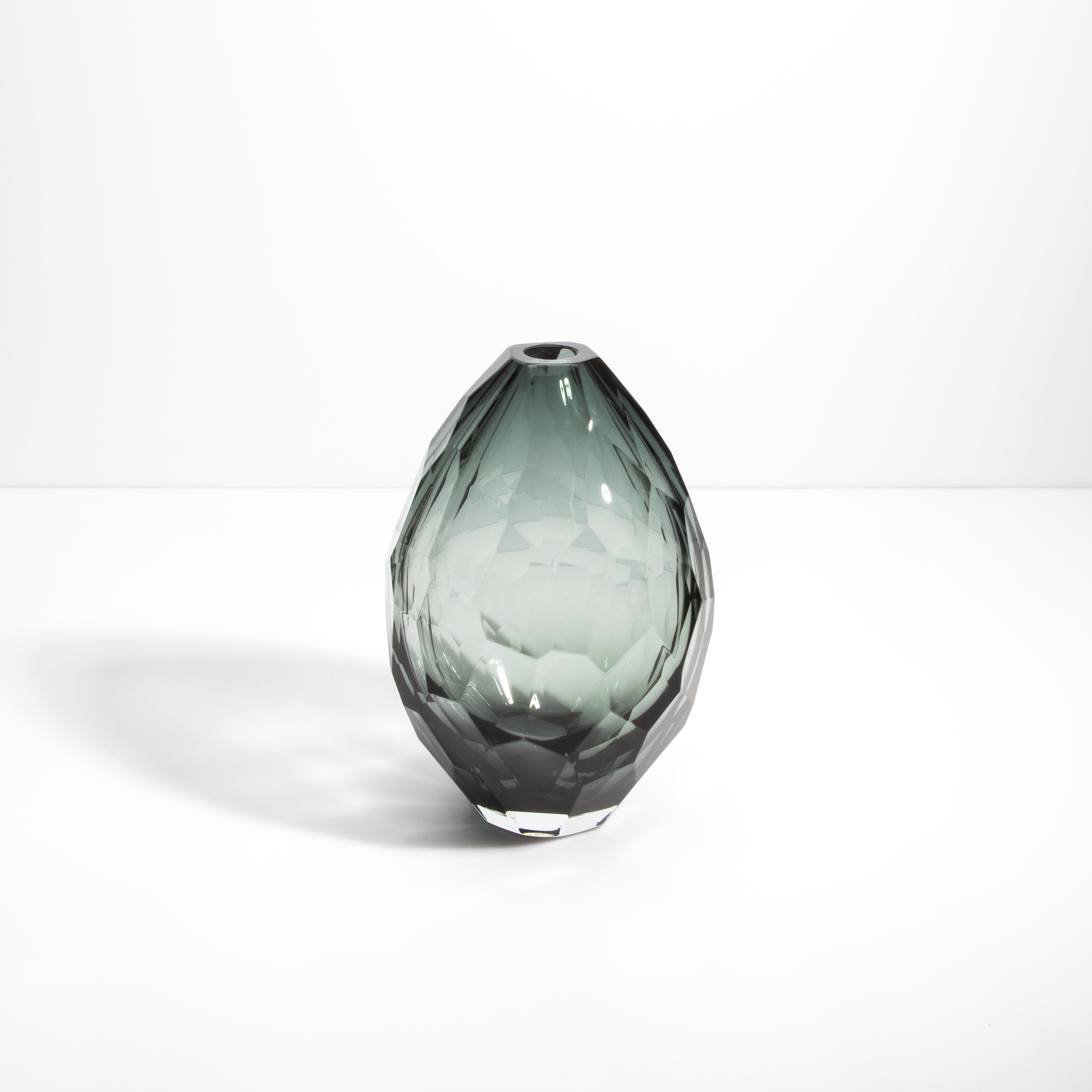 Questo squisito pezzo mette in mostra la delicata maestria e la meticolosa attenzione ai dettagli sinonimo di lavorazione del vetro veneziano. La tonalità grigio chiaro del vaso emana una serena eleganza, creando una presenza sottile ma accattivante