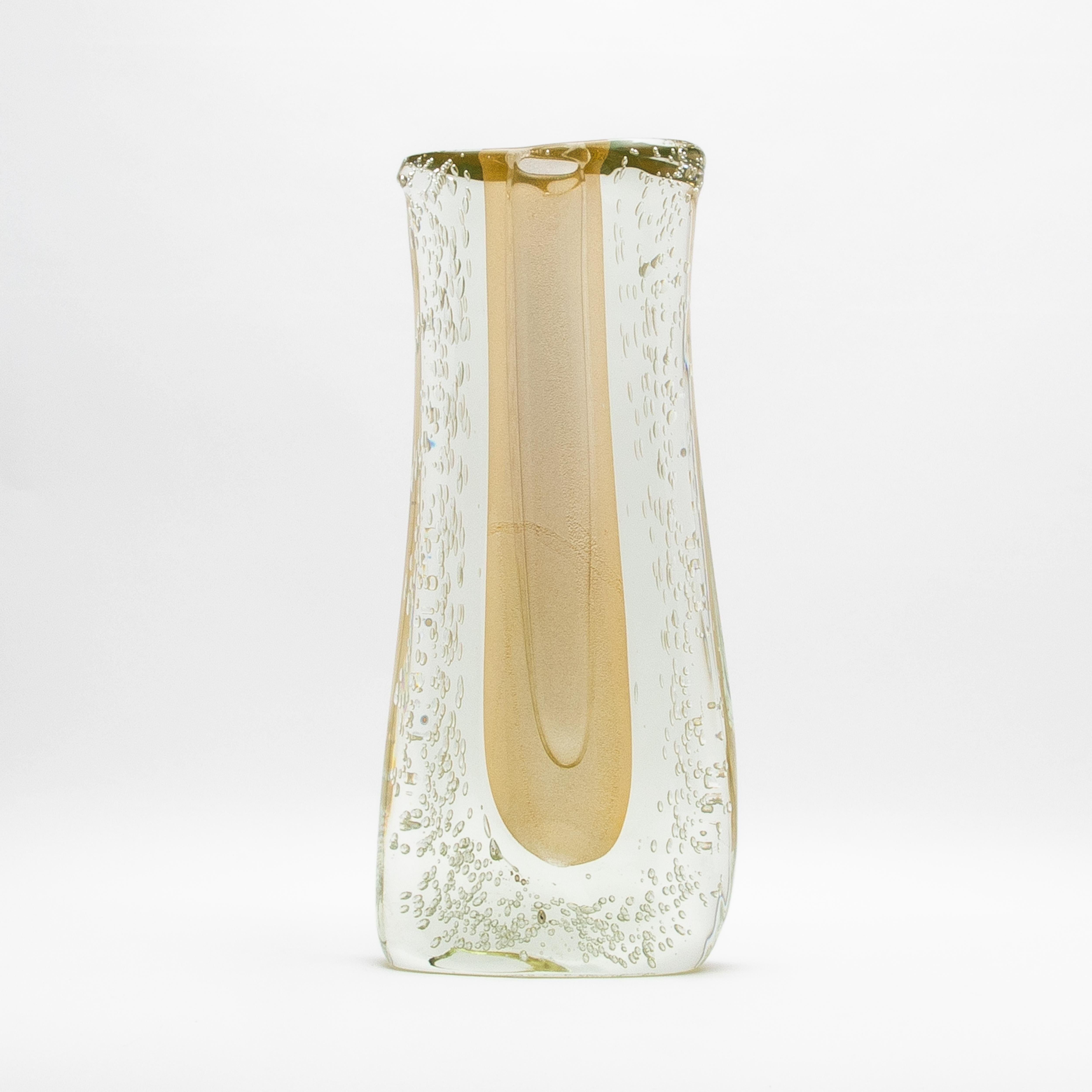 Die mundgeblasene Murano Fluid Vase ist ein eindrucksvolles Zeugnis für die unvergleichliche Handwerkskunst der Glasmeister von Murano. Diese hohe und massive Vase wird in sorgfältiger Handarbeit aus einer luxuriösen Kombination aus klarem Glas mit