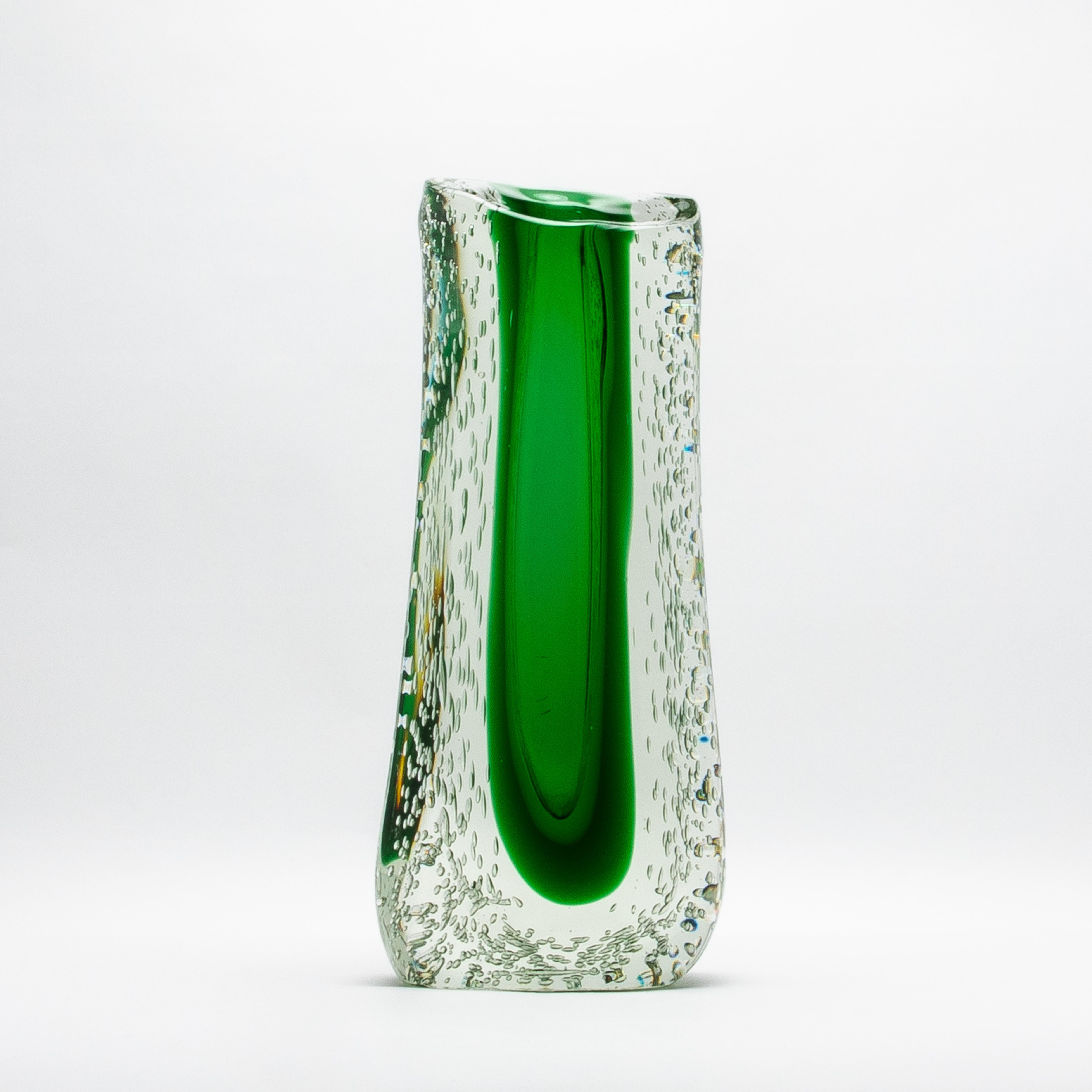 The Hand-Blown Murano Fluid Vase in Clear with Emerald Green and Bubble Details is a masterpiece of Venetian artistry, embodying the pinnacle of design and luxury. Its tall, robust form features a vibrant emerald green core encased within