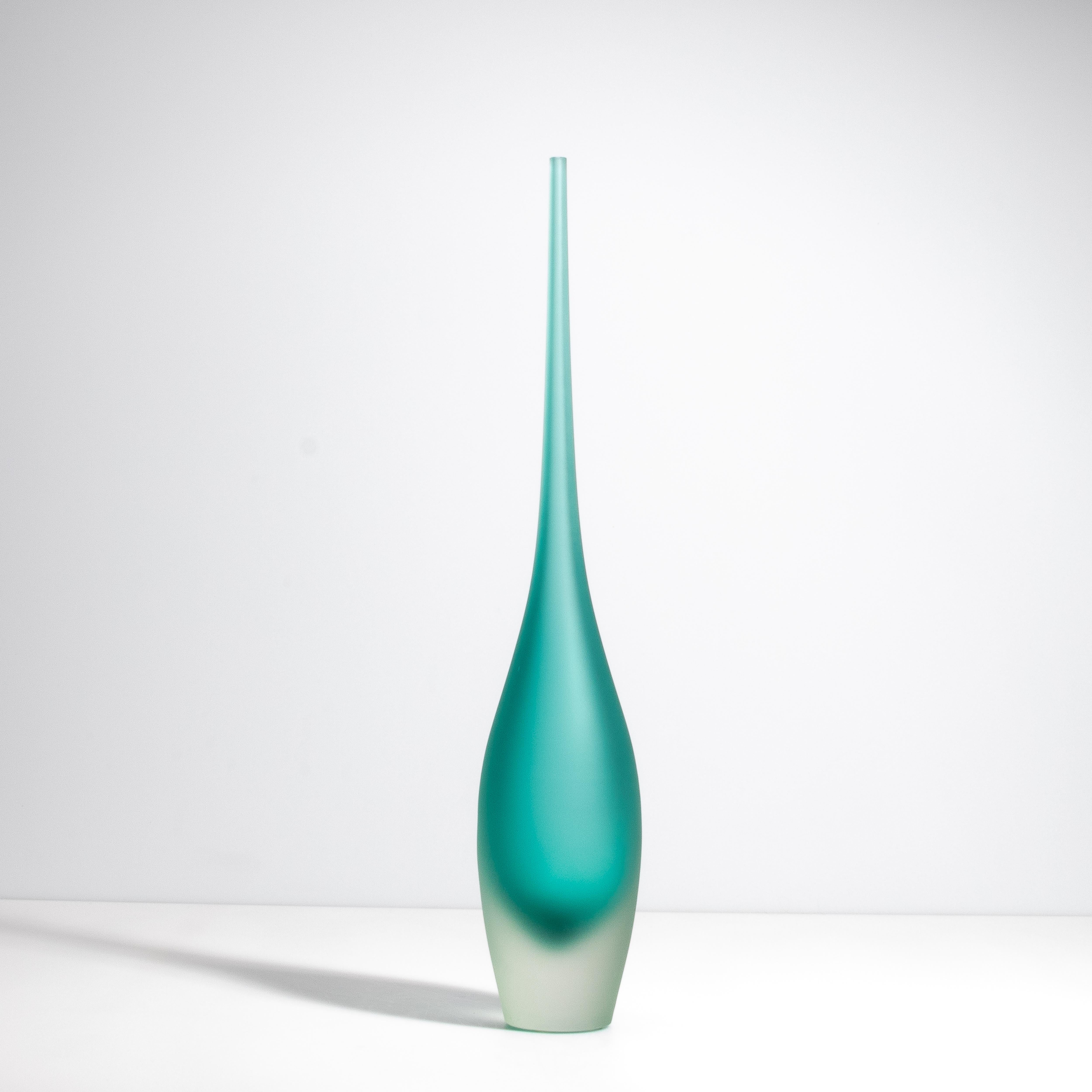 Voici notre vase flûte dans une sarcelle tranquille ; un chef-d'œuvre de verrerie artisanale qui respire l'élégance et la sophistication. Chaque courbe et contour de ce vase est méticuleusement travaillé, reflétant le dévouement et l'habileté de nos