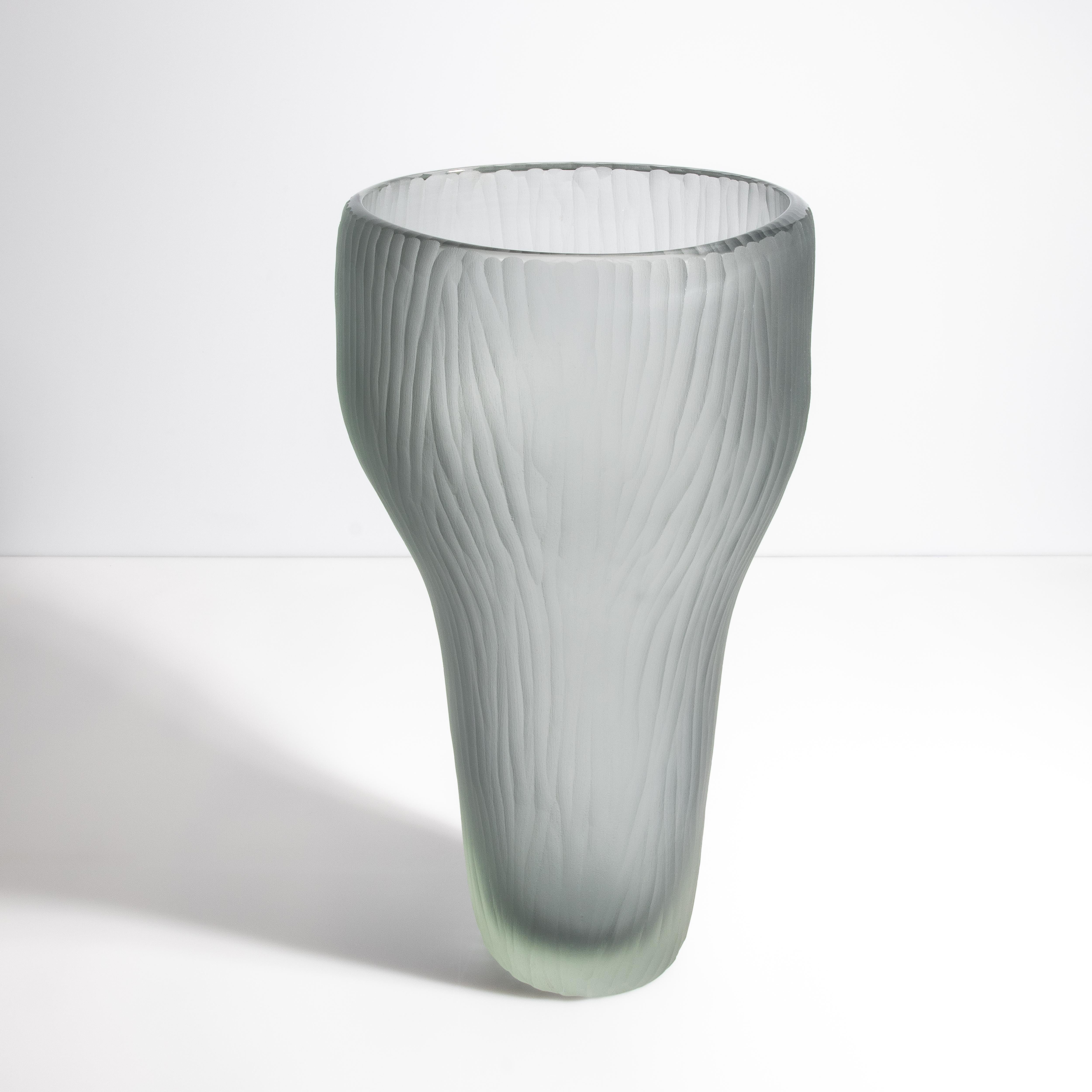Il s'agit d'une pièce vraiment remarquable, qui se distingue par son design exquis et sa couleur subtile. La teinte gris fumé ajoute une touche sophistiquée, rappelant la brume matinale sur les canaux vénitiens. La texture du vase, qui ressemble à