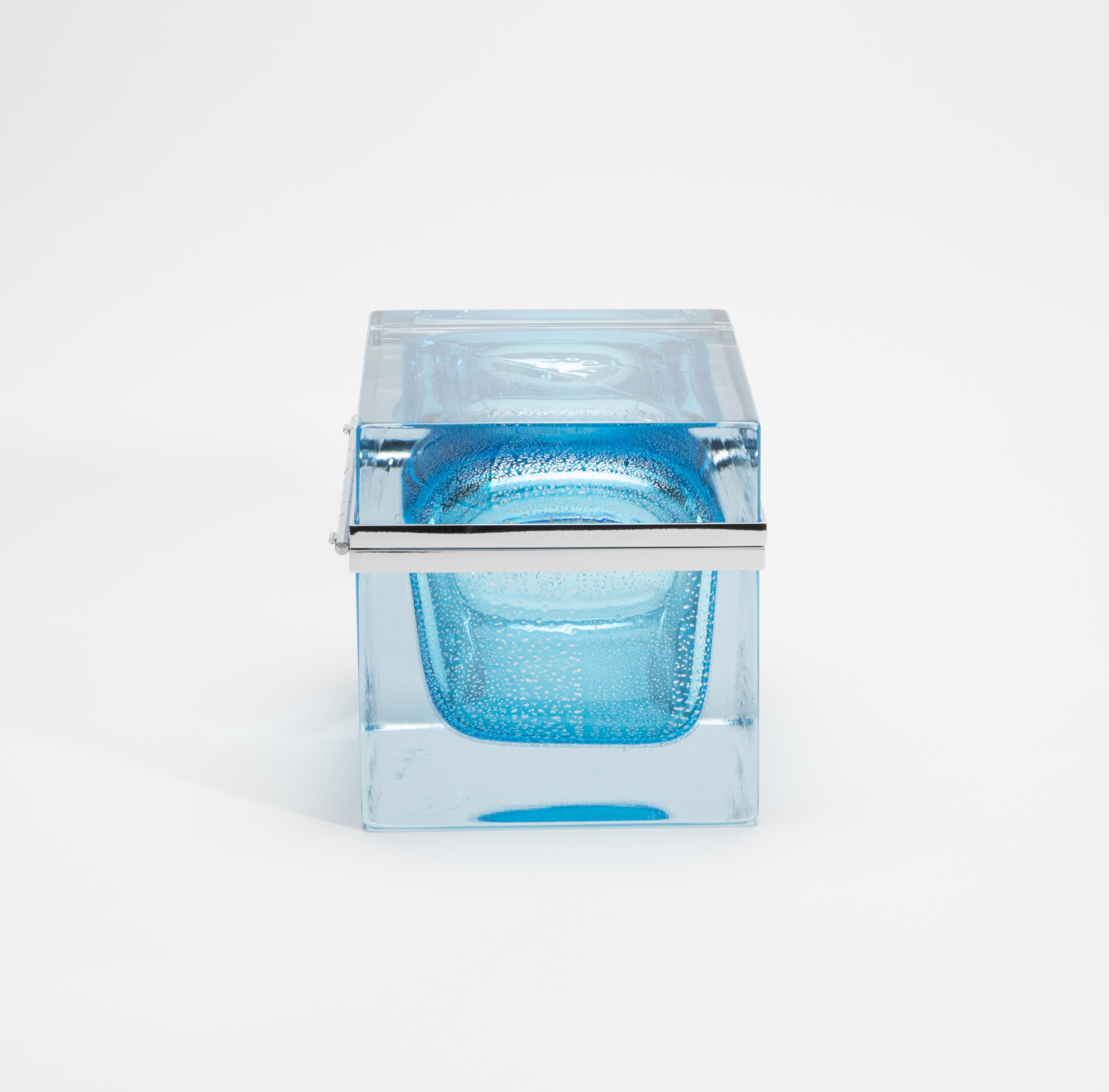Exquisita muestra de la artesanía contemporánea de Murano, esta caja gigante soplada a mano en azul aguamarina es un tesoro escultórico que combina claridad, luminosidad y refinamiento. Envuelta en una silueta gruesa y cristalina con esquinas