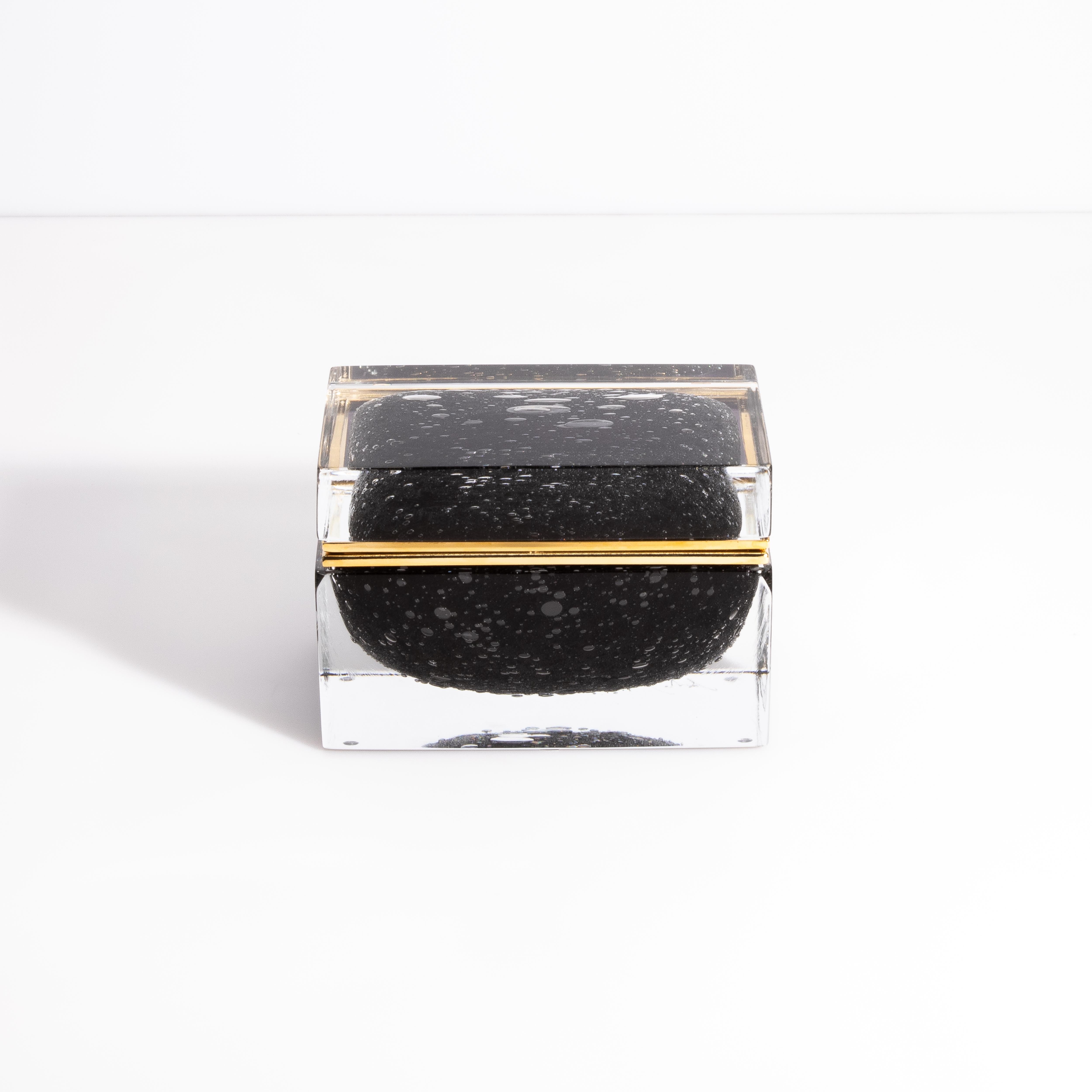 Cette boîte en verre noir Pulegoso de Murano est une fusion captivante d'art et de fonctionnalité, fabriquée sur la célèbre île vénitienne de Murano. La technique Pulegoso, qui se distingue par sa texture unique, consiste à infuser d'innombrables