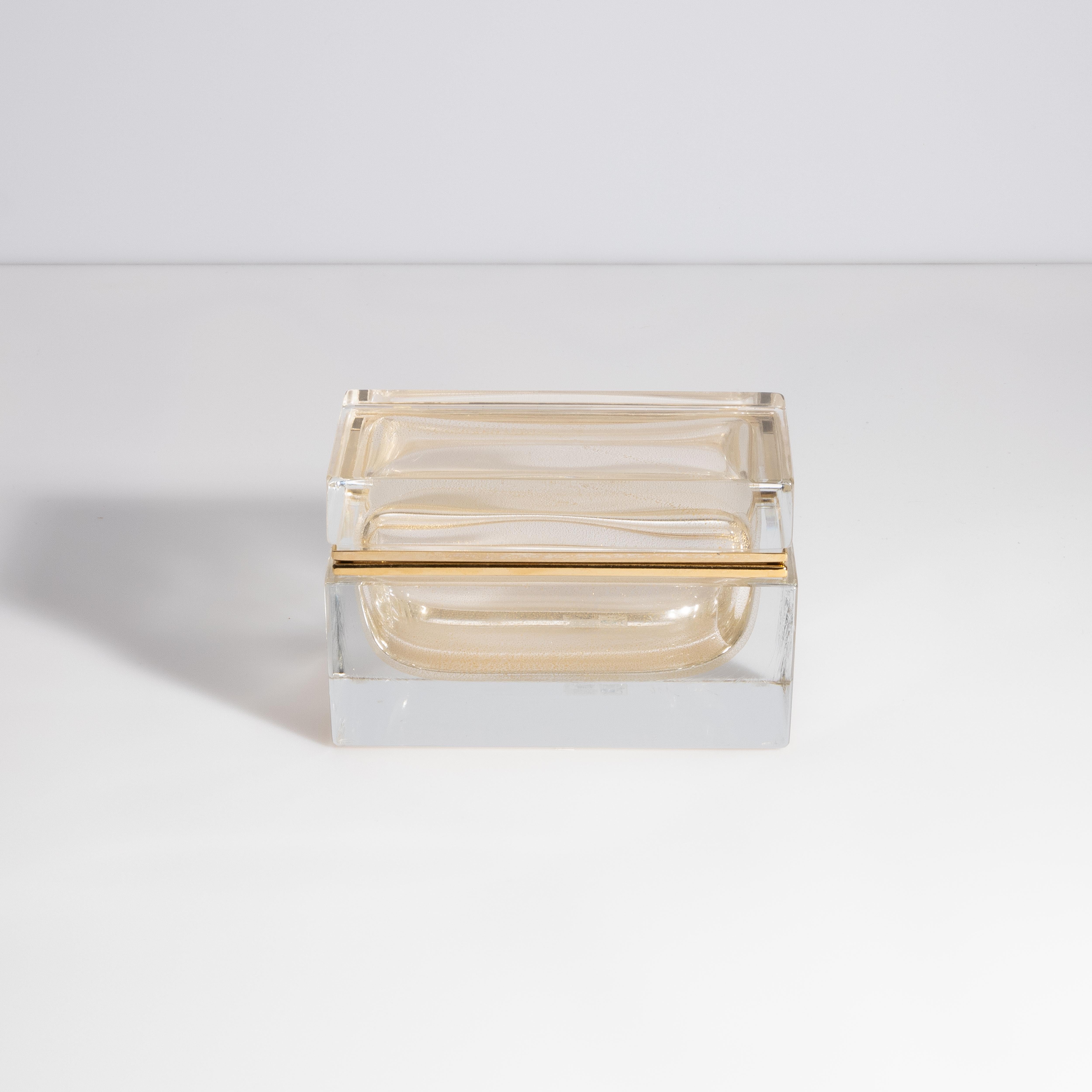 Cette boîte à bijoux en verre de Murano, en cristal avec des Elegs en or 24 carats, incarne l'élégance et la sophistication avec son design intemporel et ses matériaux luxueux. Fabriquée à la main sur l'île mythique de Murano, cette boîte à bijoux