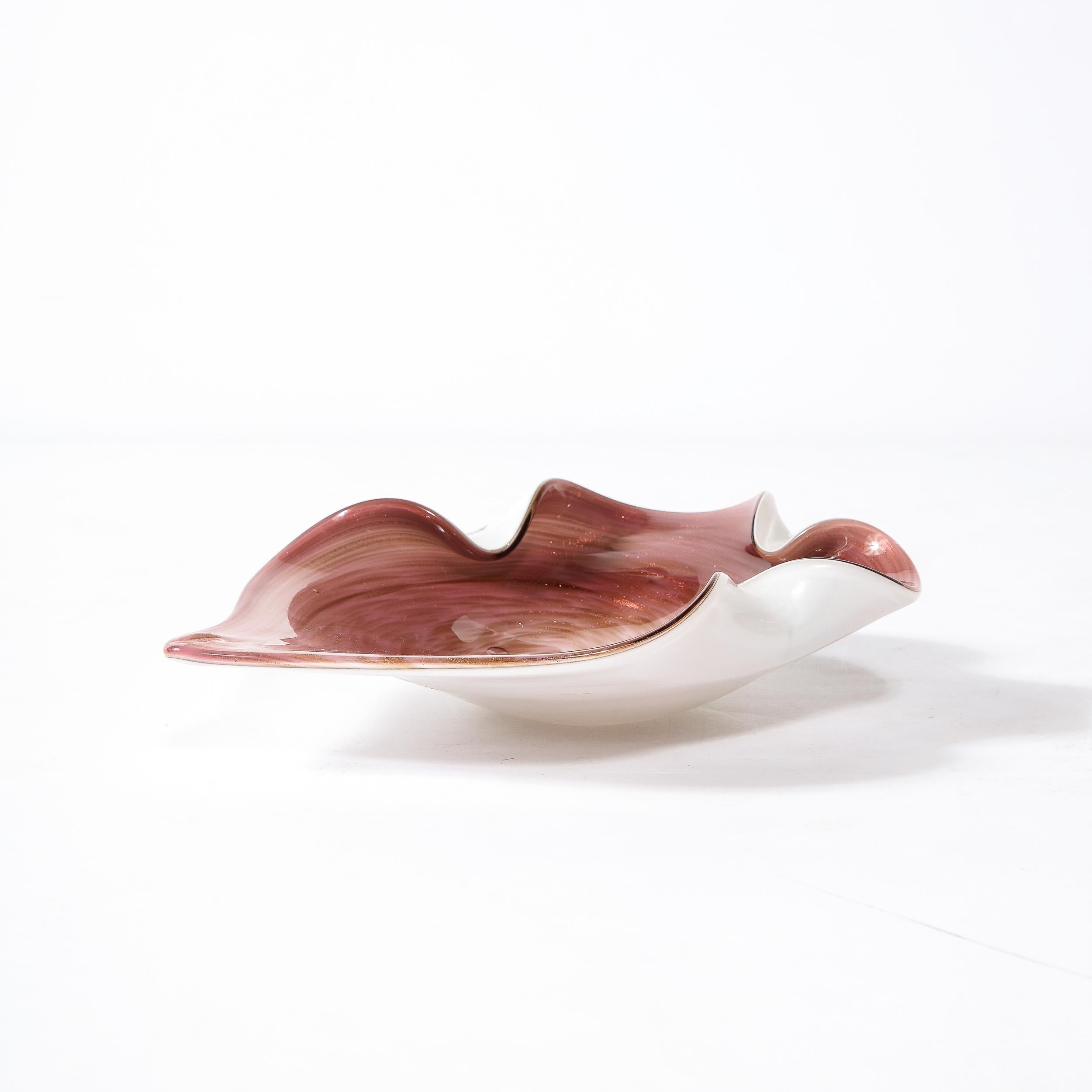 A stunning Hand-Blown Murano Glass Dish originates from Italy Circa 1960, rendered in a stunning amethyst hued glass, spun to meld with the undersurface hue in pearl white crimped detailing on three edges with one extended like a flower in the midst