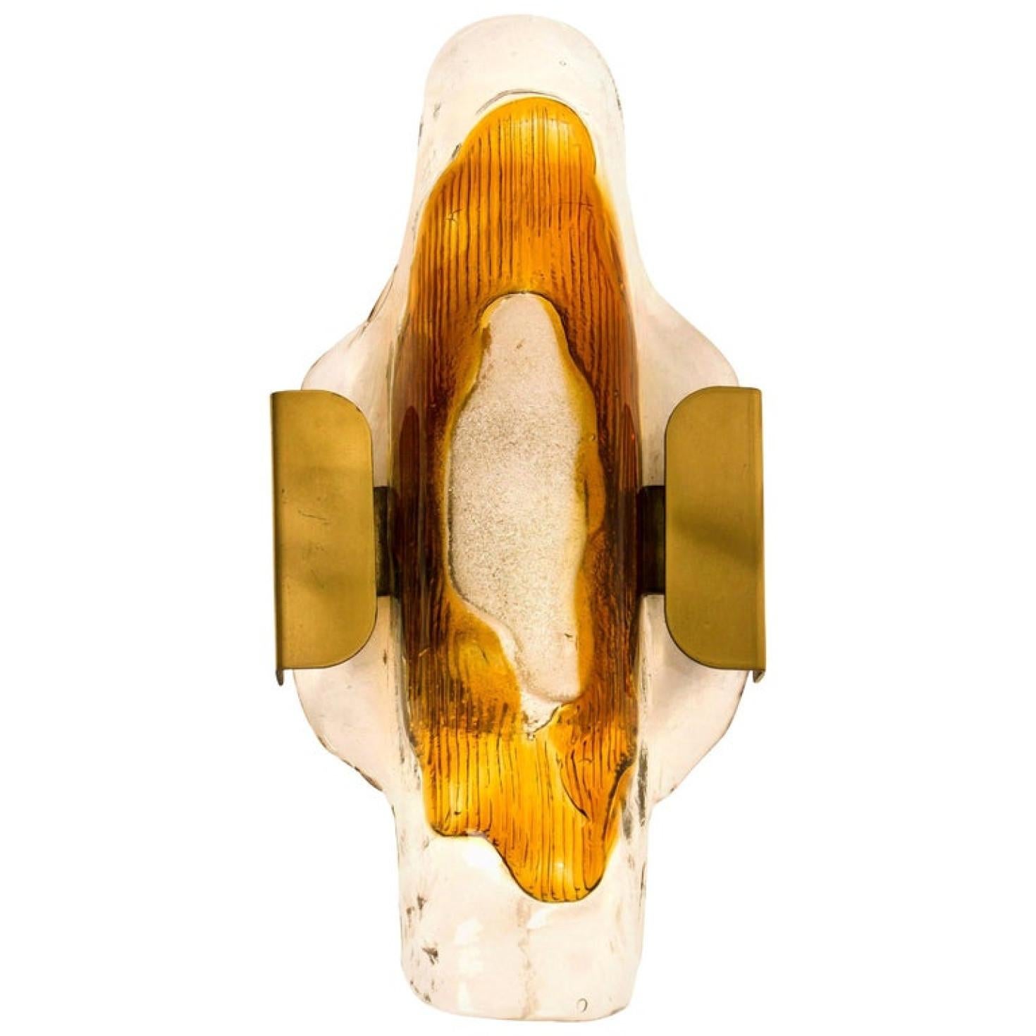 beautiful wall sconce in the style of Mazzega, manufactured in the Mid Century, circa 1970 (end of 1960s and beginning of 1970s). A brass frame and a bi-colored (clear and orange) hand blown glass. Each piece of glass meticulously hand formed in