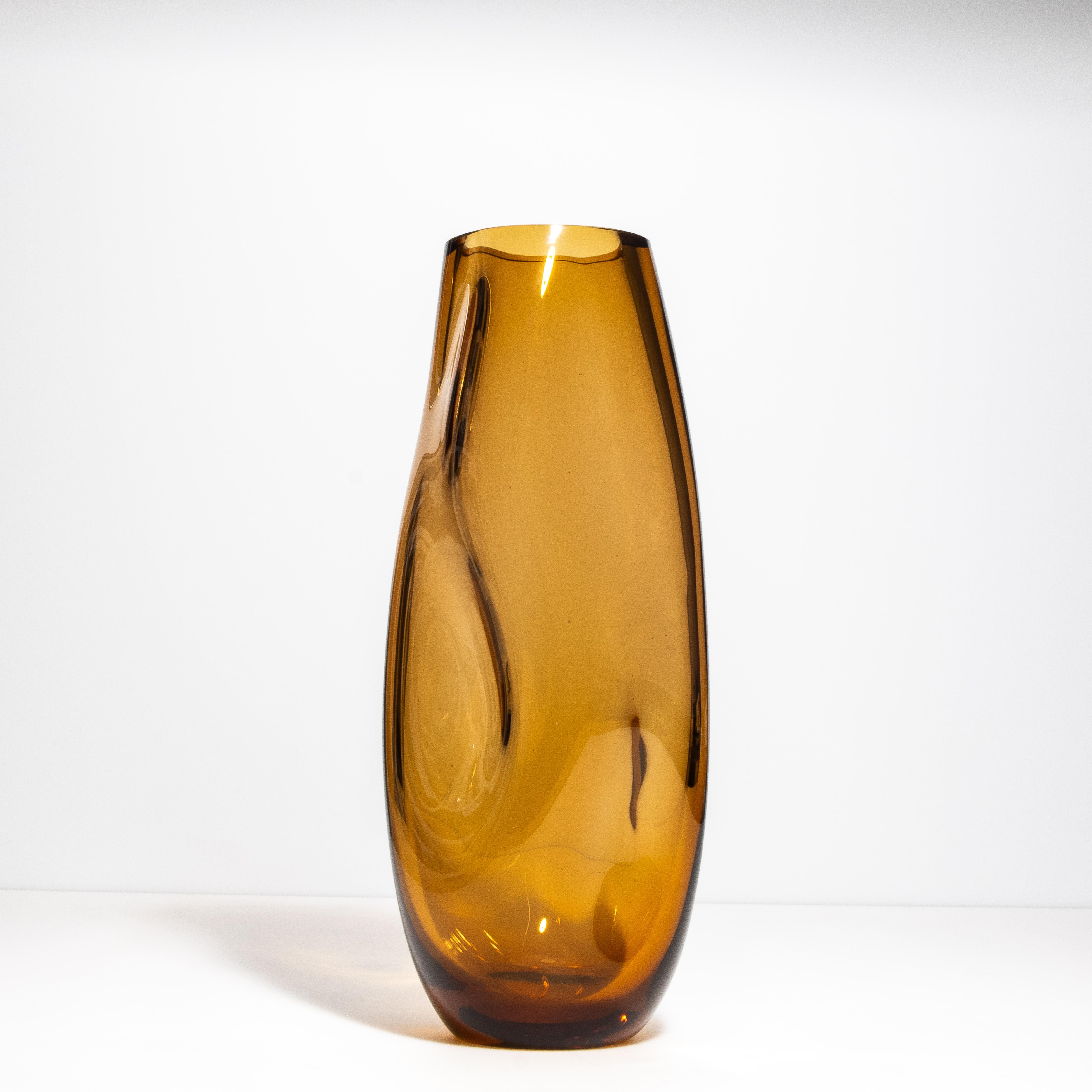 Ti presentiamo il nostro vaso frastagliato in una profonda e lussuosa tonalità ambrata, epitome di raffinata eleganza ed eccellenza artigianale. Realizzato da abili artigiani del vetro di Murano, questo vaso presenta un design unico con sottili