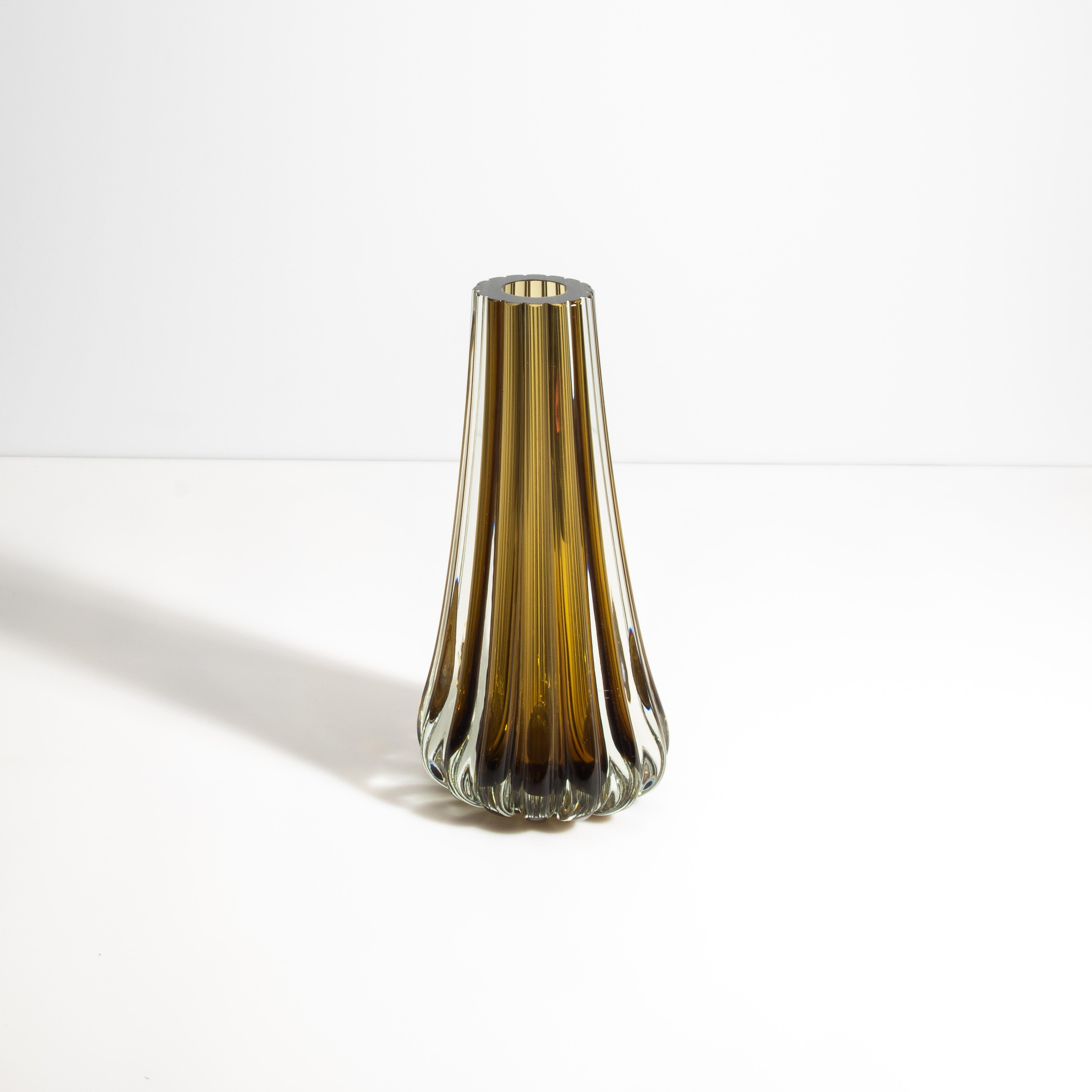 Questo vaso Massiccio, unico nel suo genere, incarna un'eleganza raffinata e un lusso senza tempo, realizzato meticolosamente a mano da maestri artigiani nel rinomato distretto vetrario di Murano, in Italia. Il vaso presenta un sorprendente design
