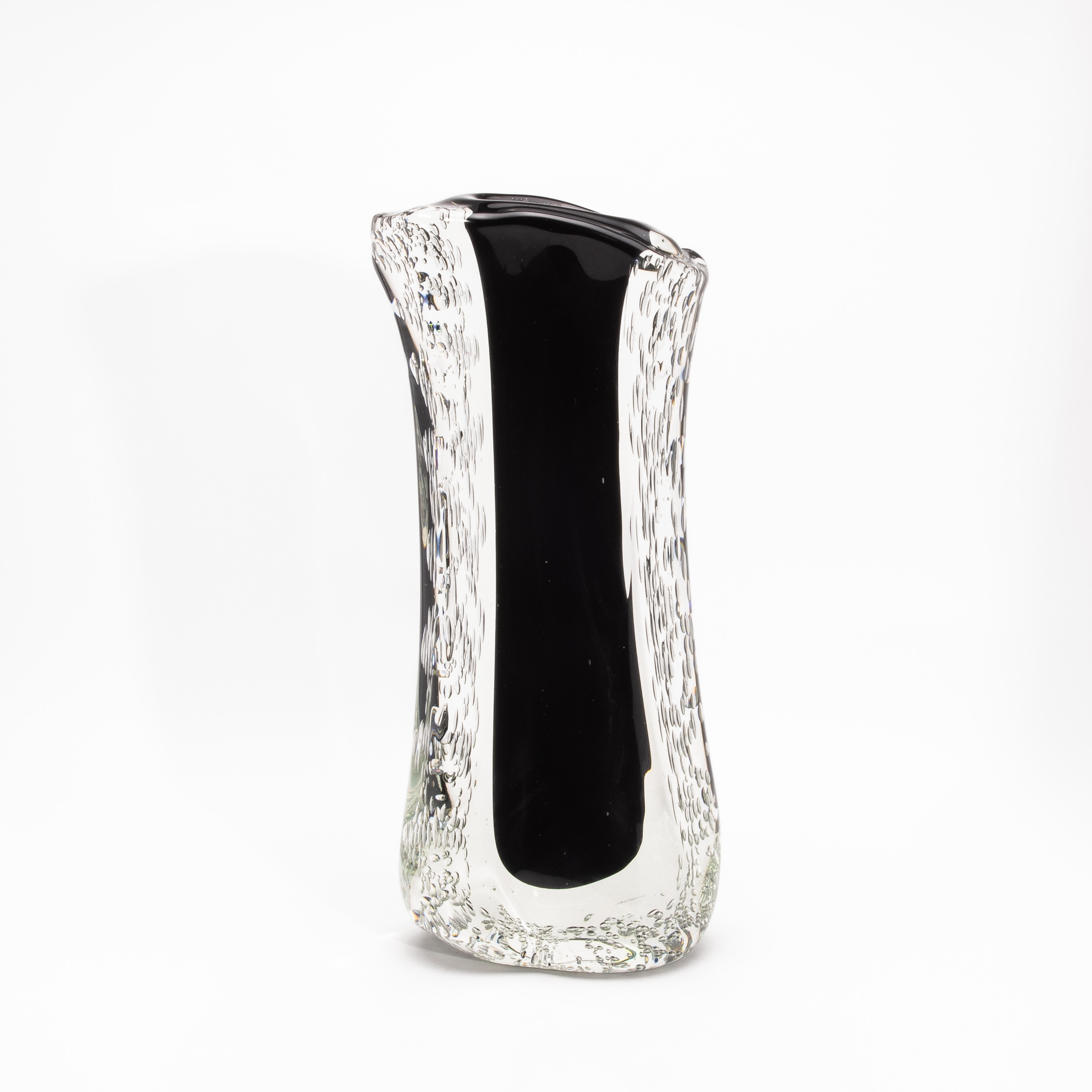 Ce vase de Murano, soufflé à la main, attire l'attention par sa forme statuaire de 22 pouces et constitue un exemple frappant de l'art du verre moderne. Le cœur noir onyx, audacieux et raffiné, s'élève à travers une cascade de verre cristallin qui