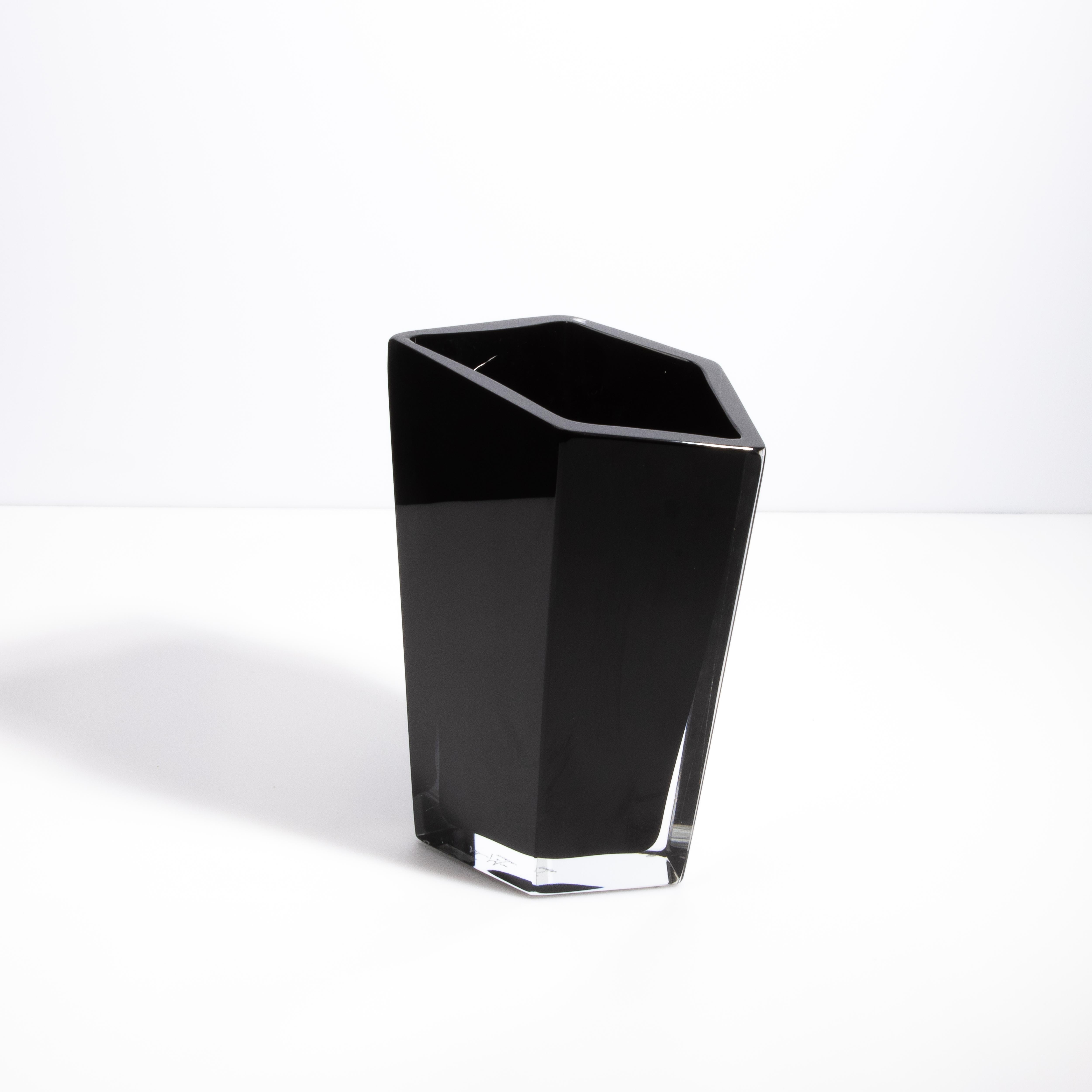 Questo vaso in onice nero, squisito pezzo di arte vetraria di Murano, è uno splendido esempio di eleganza contemporanea e di artigianato senza tempo. Realizzato a mano dai maestri vetrai di Murano, questo vaso presenta un design angolare unico che
