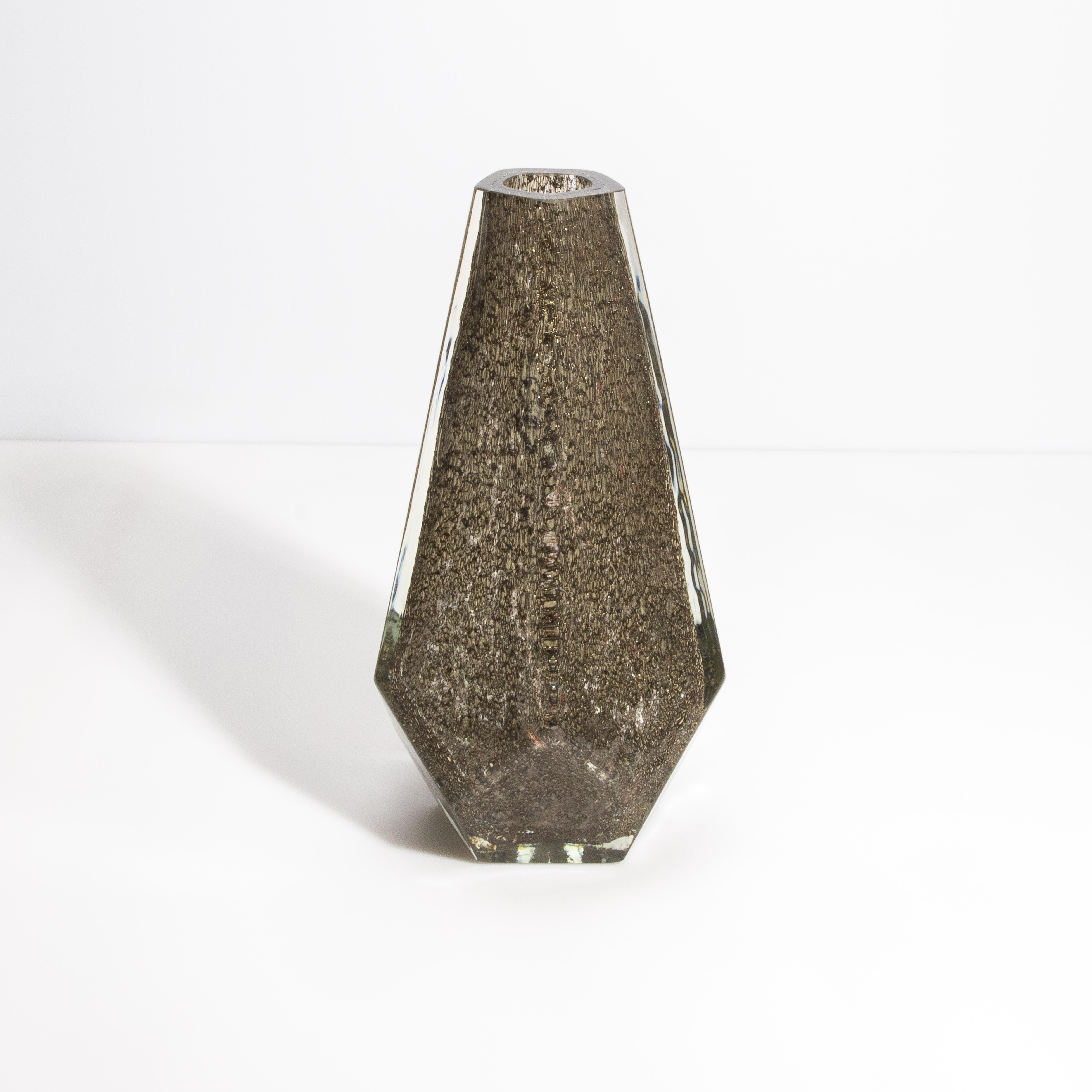 Unsere exquisite fünfeckige Vase ist eine meisterhafte Kreation, die modernes Design und zeitlose Eleganz nahtlos miteinander verbindet. Umhüllt von einem makellosen, klaren Äußeren, enthüllt die Vase eine faszinierende mittlere Schicht in einer