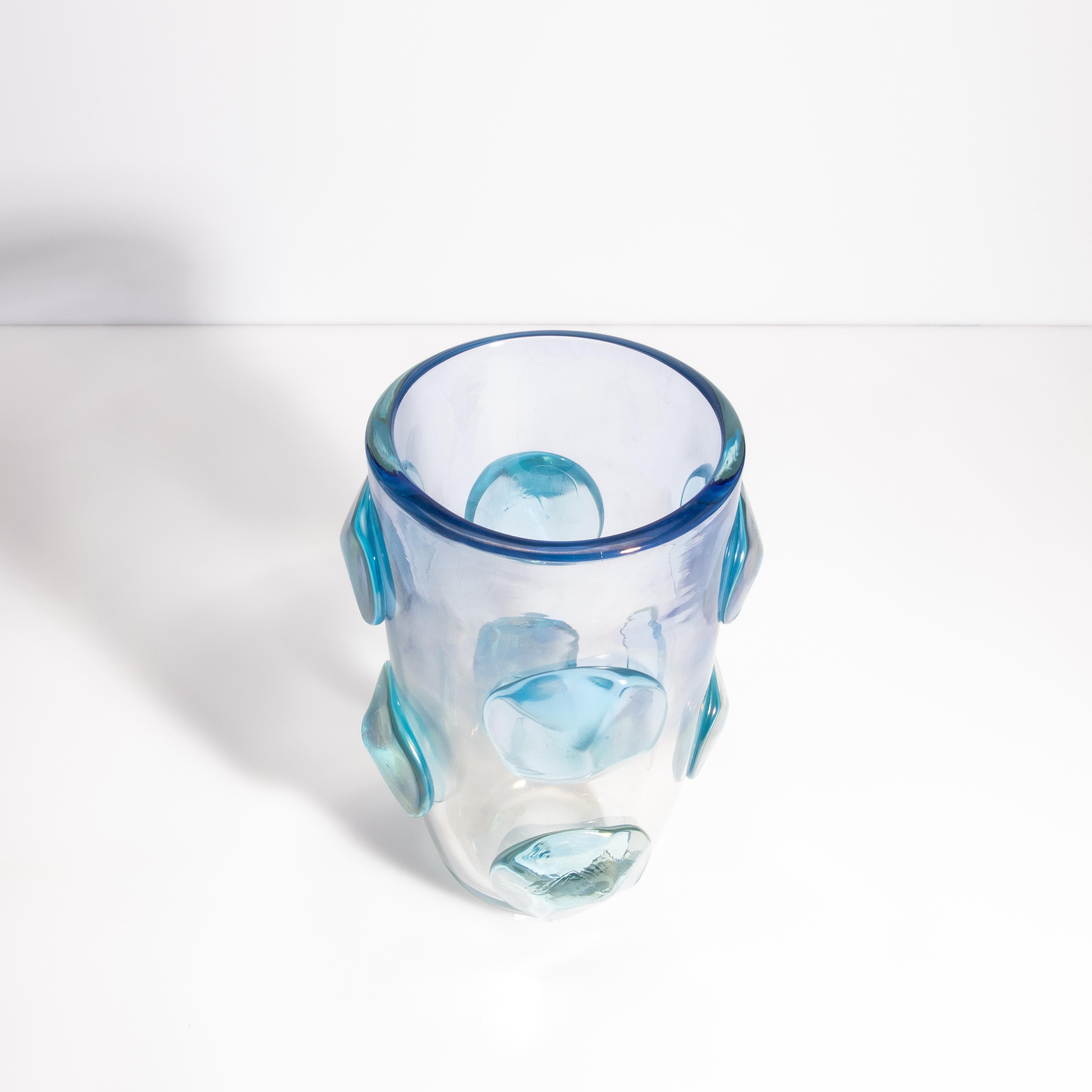 Questo squisito pezzo è una vera e propria testimonianza dell'eleganza senza tempo e della maestria innovativa che caratterizza il vetro di Murano.
L'elegante forma cilindrica del vaso è impreziosita da un secondo strato di vetro, ornato da