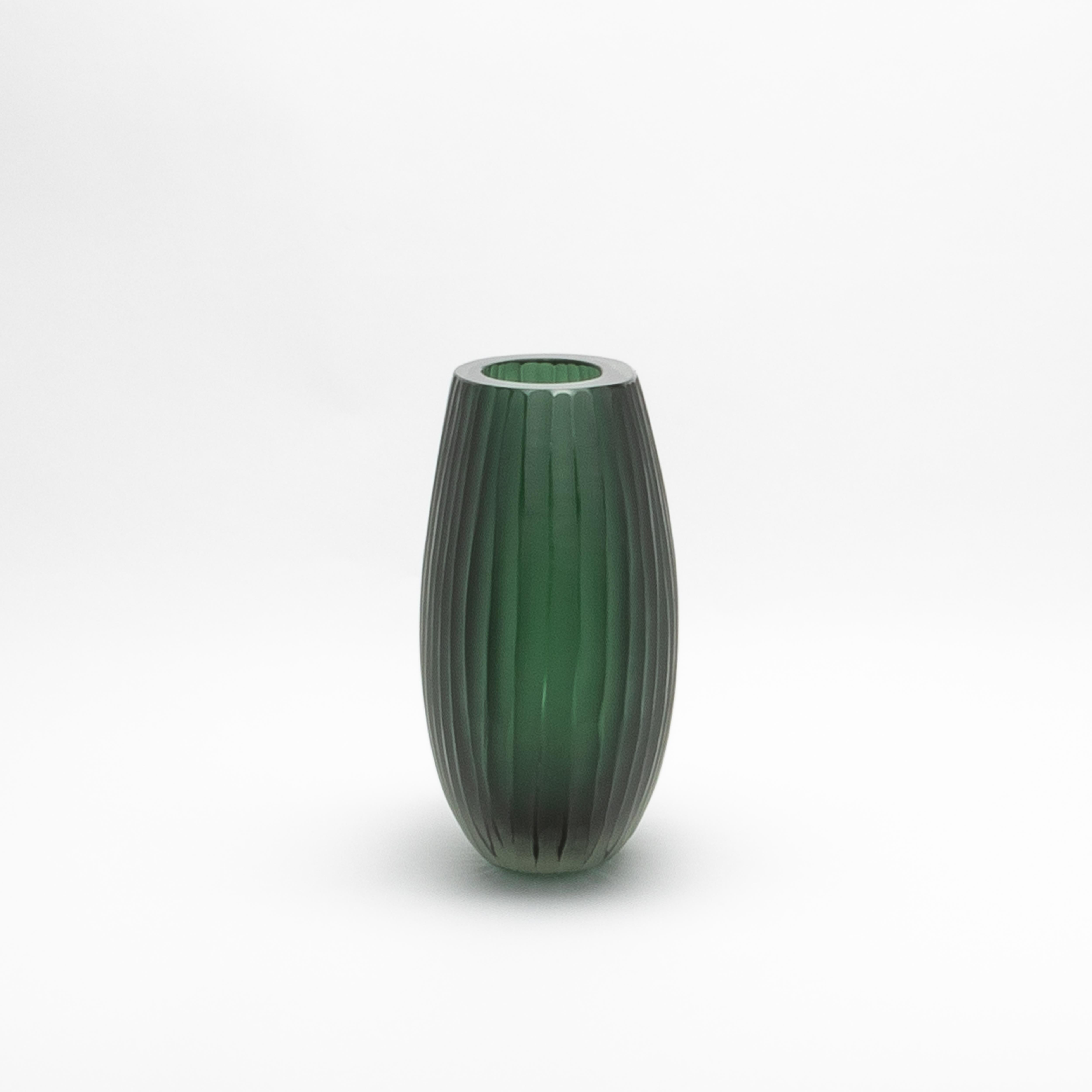 Il Vaso Supremo di Murano soffiato a mano in verde smeraldo emana un'eleganza senza tempo, fondendo vetro smerigliato e trasparente in un capolavoro armonioso. La sua texture delicatamente rigata crea un gioco dinamico di luci e ombre, accentuando
