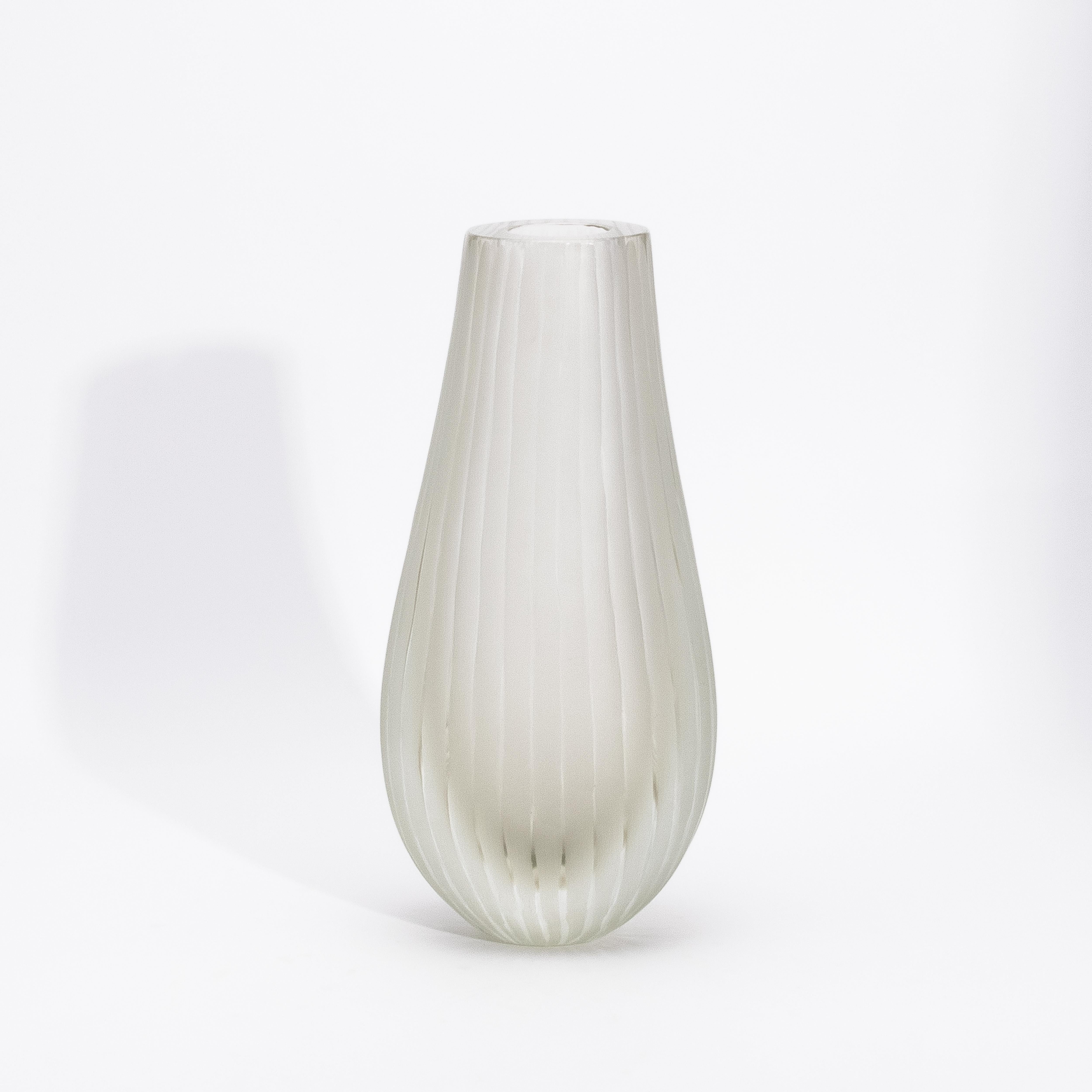 Realizzato nel cuore di Murano da maestri artigiani, il Vaso Surpime in Citrino incarna la serena eleganza dell'alta vetreria italiana. Il suo delicato tono dorato, morbido e luminoso come la nebbia del mattino, è racchiuso in una superficie