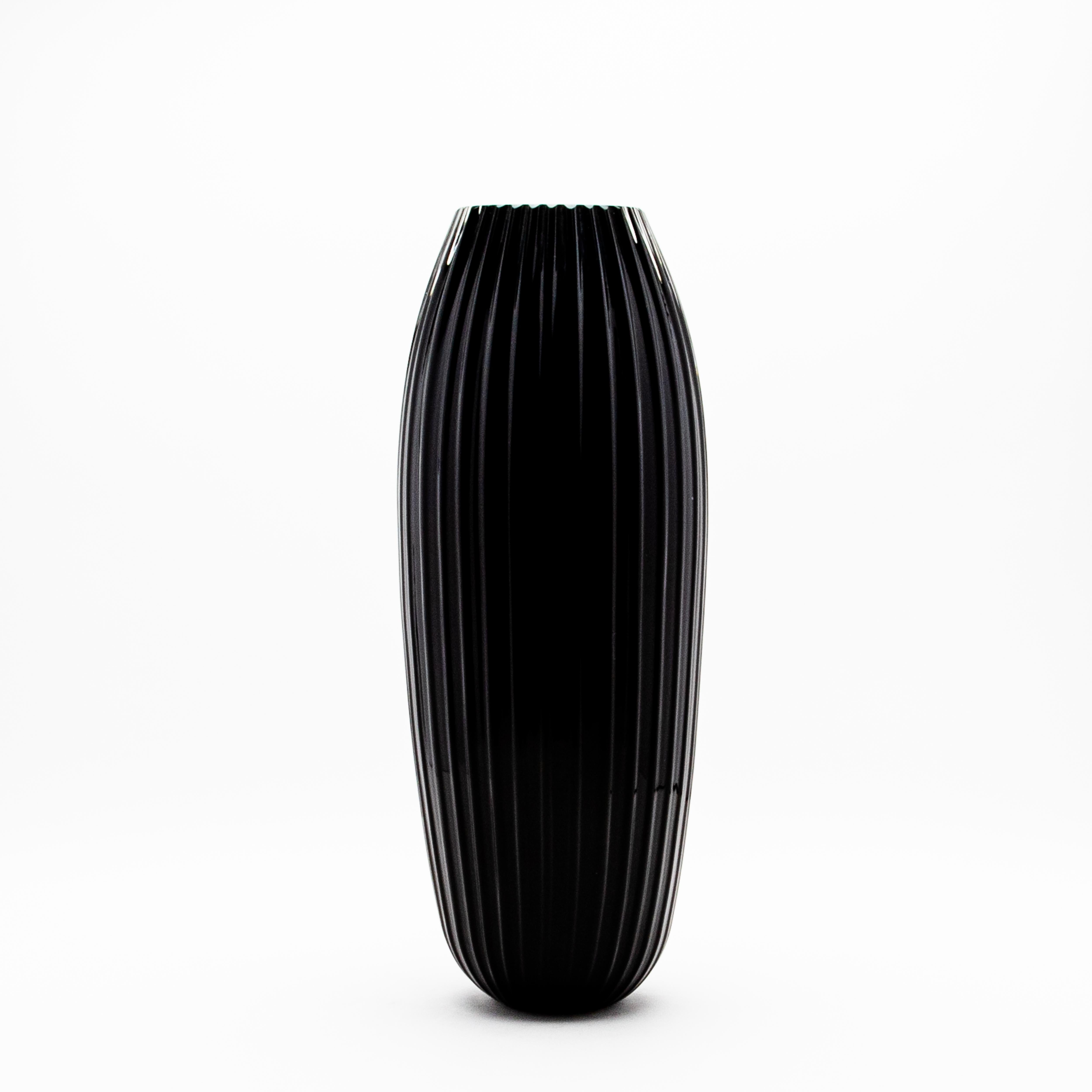Questo vaso di Murano alto e sorprendente in nero onice incarna l'Eleganza e la sofisticata artigianalità italiana, perfetta per aggiungere un tocco di opulenza a qualsiasi interno. Sapientemente soffiato a mano dai migliori artigiani di Murano,