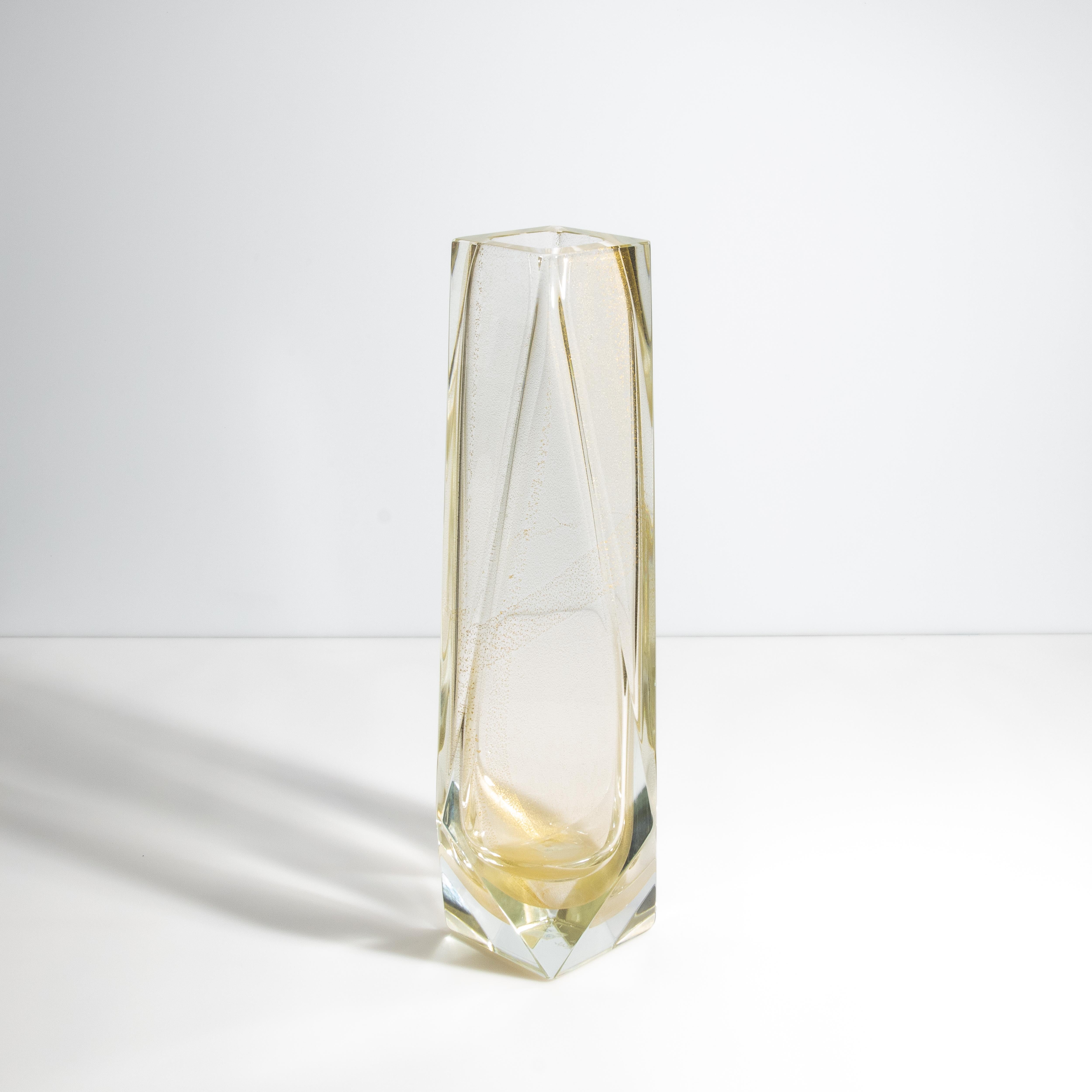 This hand-blown Goccia vase, crafted in Murano, a small island in Venice, exudes timeless elegance and sophisticated design. It showcases a seamless transition from a clear glass base to a 24-karat gold flecks, creating a striking visual symphony