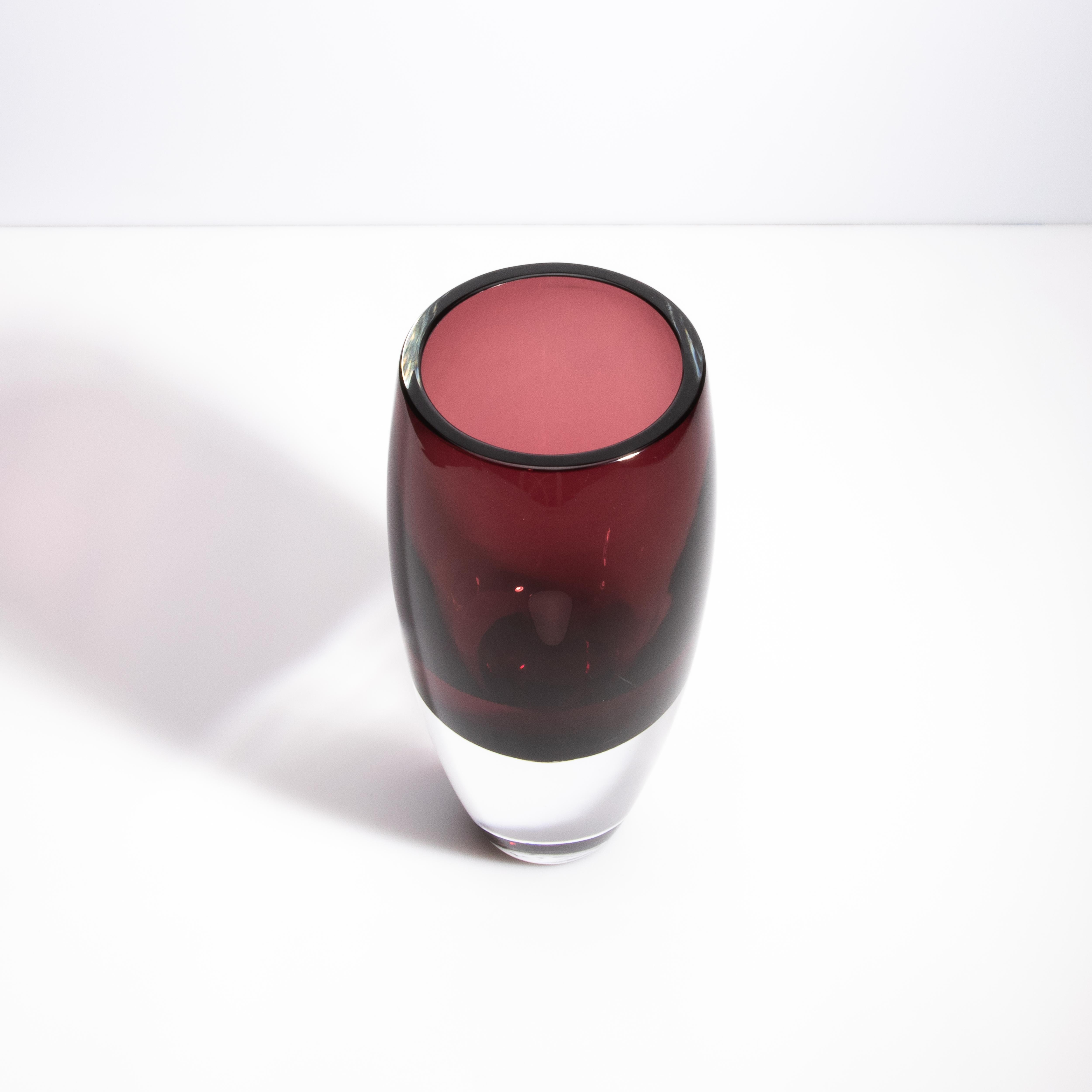 Questo squisito vaso soffiato a mano proveniente dall'isola di Murano, vicino a Venezia, è uno straordinario esempio di arte vetraria veneziana. Il vaso presenta un bellissimo fondo trasparente che passa senza soluzione di continuità a una