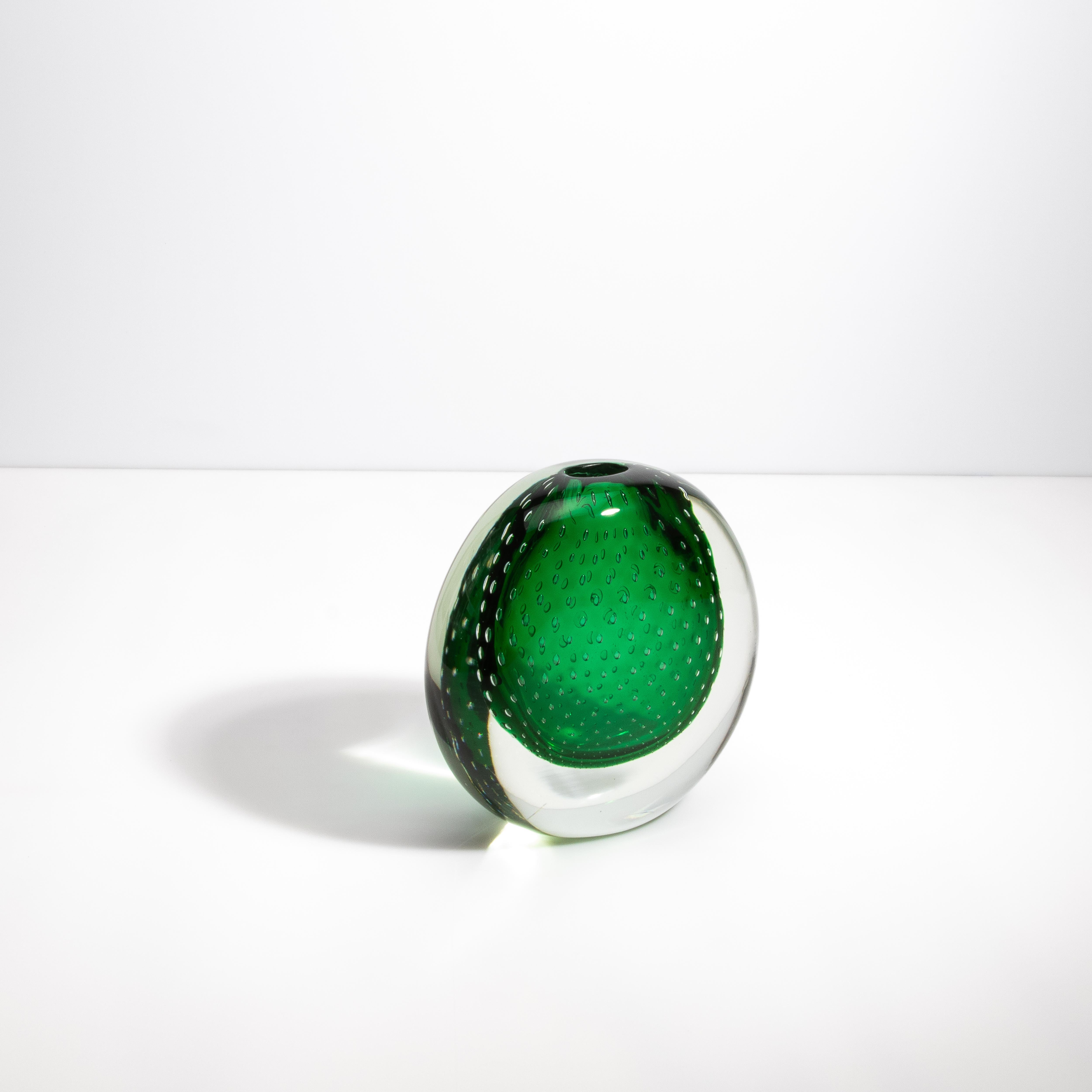 Ispirandosi ai paesaggi lussureggianti e alle acque serene che circondano Venezia, il vaso Pois Greene Greene Murano incarna un senso di naturale eleganza e tranquillità. La ricca tonalità smeraldo e le bolle meticolosamente lavorate incapsulate