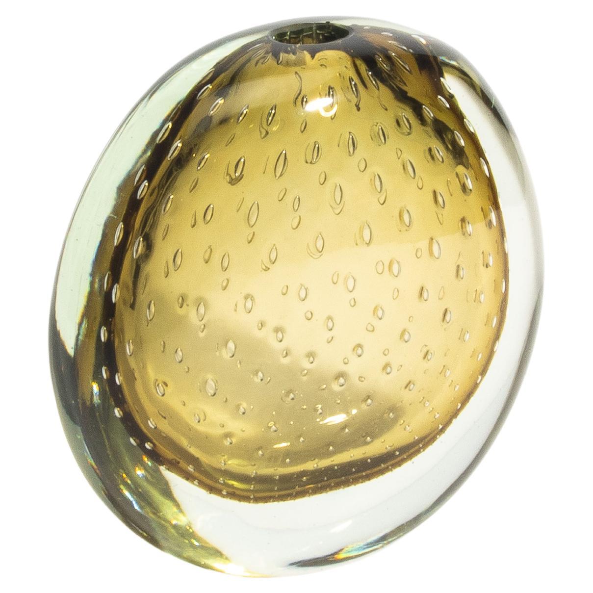 Realizzato con l'intramontabile tecnica del Bullicante, questo vaso di Murano soffiato a mano incarna la meticolosa maestria dei vetrai veneziani. Ogni bolla è accuratamente incapsulata in strati di vetro, creando una profondità e una consistenza