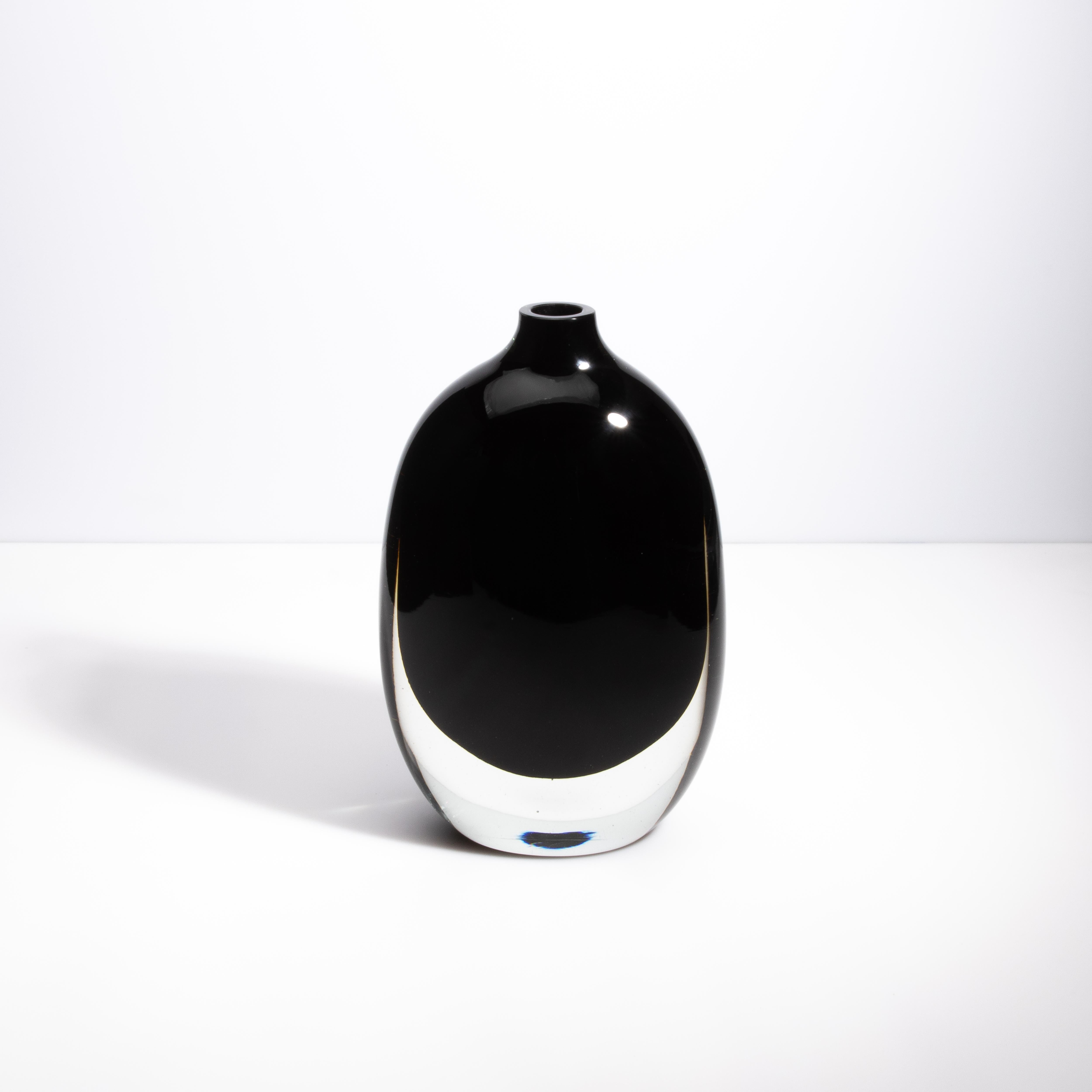Questo vaso di Murano Glass Sommerso è uno splendido esempio di arte vetraria veneziana, che combina vetro trasparente e nero onice in un design sofisticato ed elegante. Realizzato a mano dai maestri artigiani di Murano, questo vaso è caratterizzato