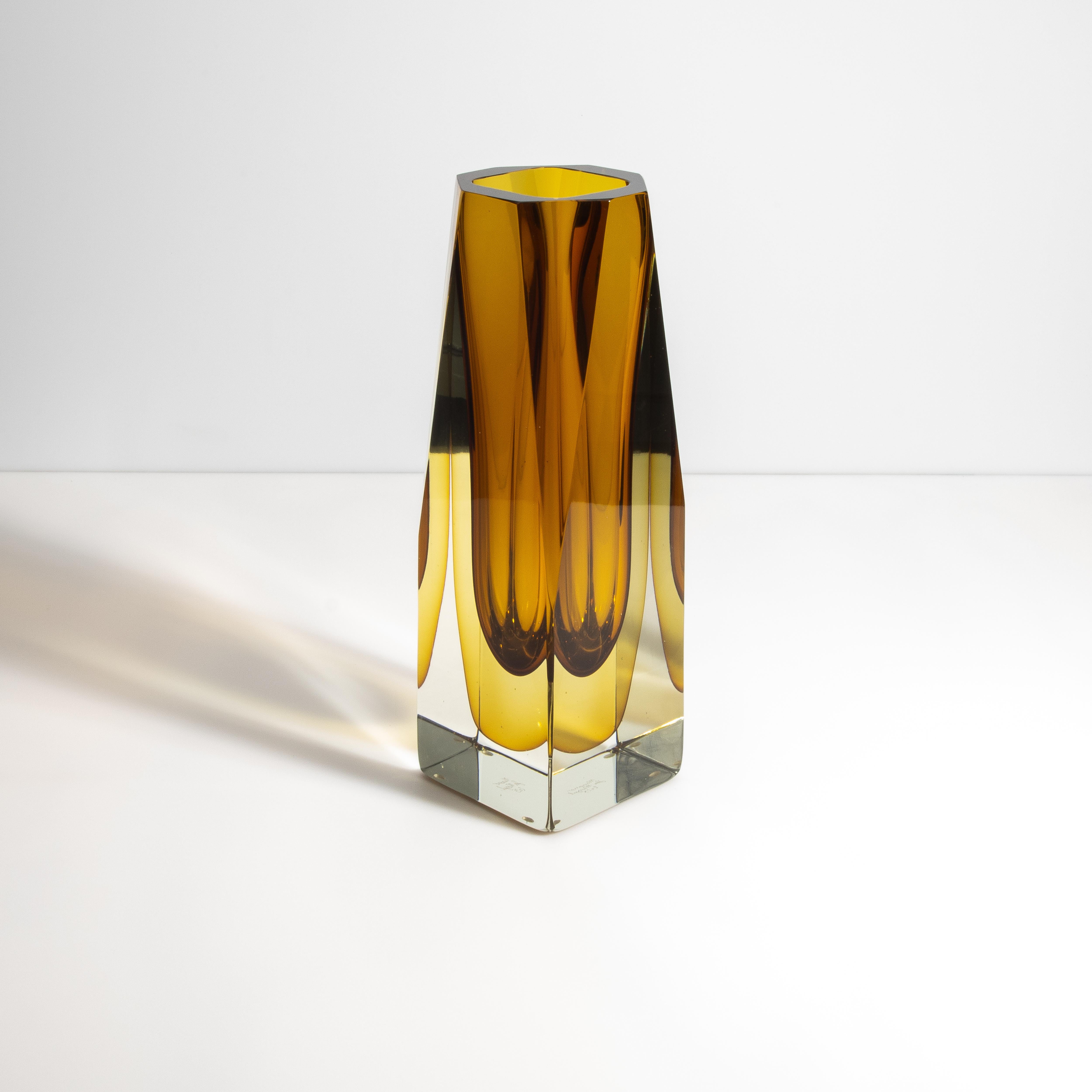 This striking rectangular vase showcases a captivating combination of amber hues and crystal-clear glass, evoking a sense of timeless elegance and sophistication. The seamless blend of these two elements creates an enchanting visual effect that