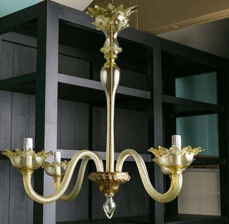 This elegant Murano chandelier has a tall stem and is simple and Classic. It has a subtle olivine color that is a bit chameleon-like in that it picks up the colors of a room.