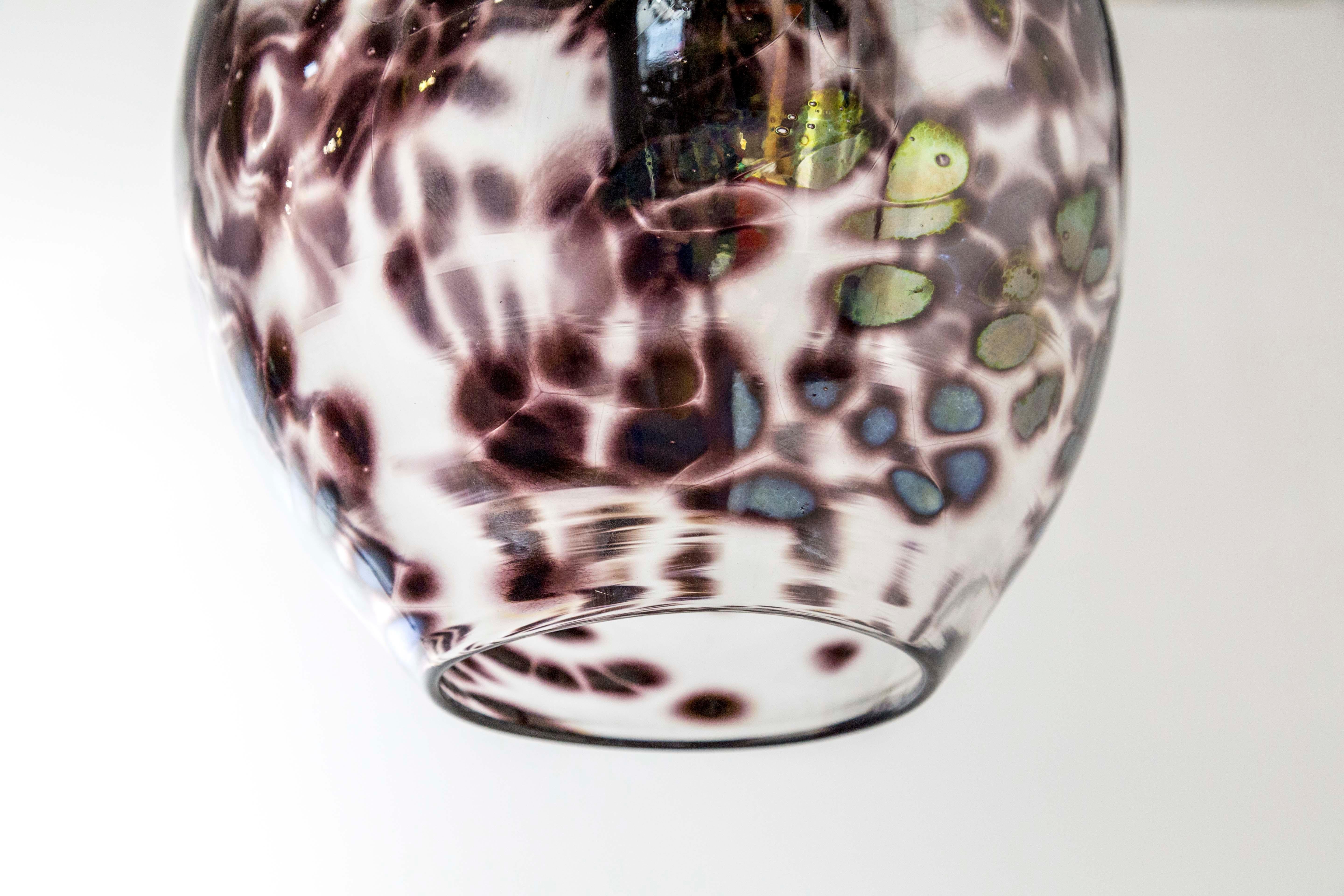 Hand blown, clear and purple / burgundy spotted glass pendant lights; hanging from long, black chains. The spots have an 
