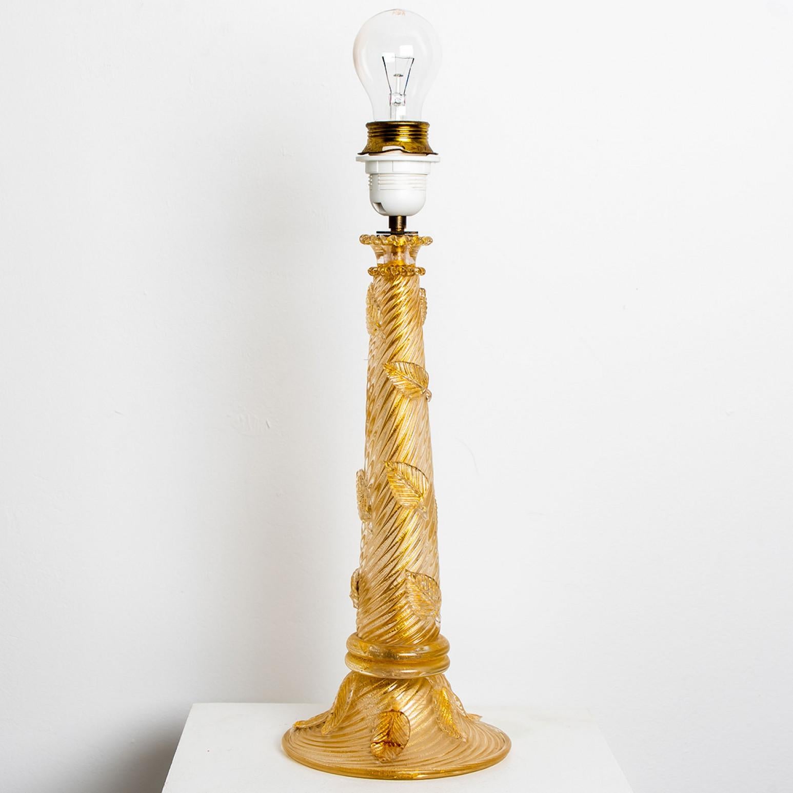 This elegant Mid-Century Modern table lamp was hand-blown in Murano, Italy by studio Barovier & Toso, circa 1950.


The lamp shows a beautiful pilar with several leaves in a vibrant color palette with special gold inclusions. The table lights fills