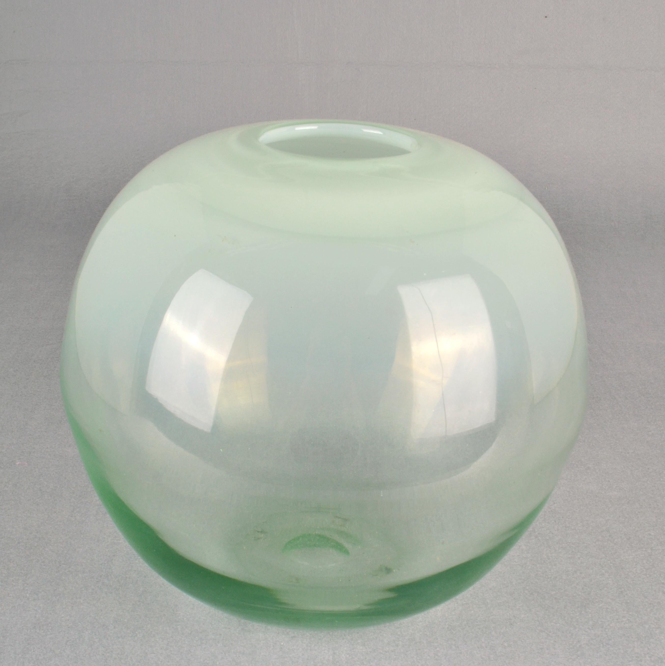Handgeblasene, schwergewichtige Kugelvase aus klarem Glas, das oben in Opalin übergeht und unten grün ist, von Copier, Leerdamer Glashütte, Niederlande, 1960er Jahre. 
Glasmacher und Designer  Andries Dirk Copier (1901-1991) gilt als der