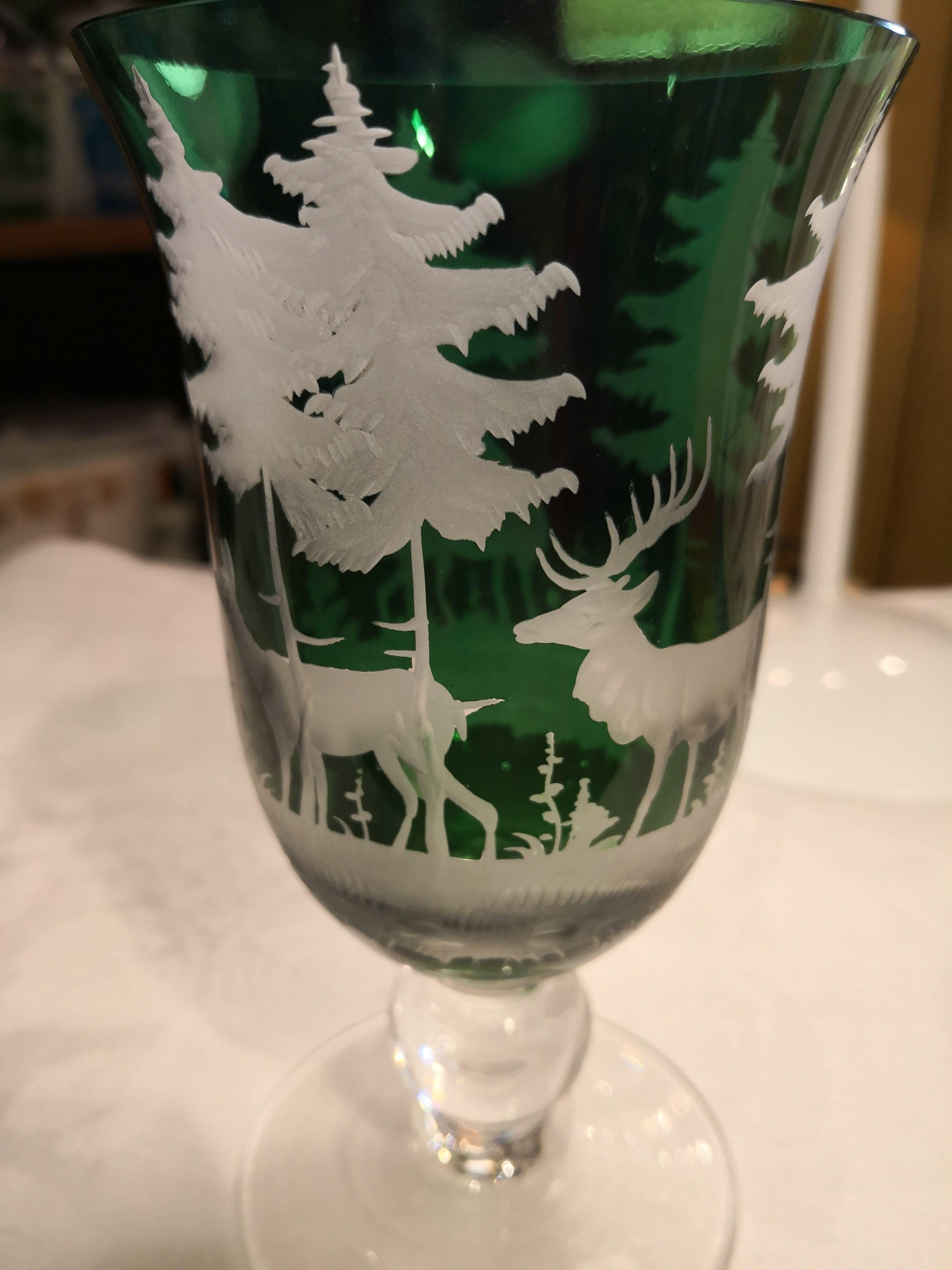 Hand blown wine goblet in green crystal with an antique hunting decor all around. The charming hand-engraved decor shows deers and trees in the style of Black Forest. The pedestal comes in is clear crystal and the goblet is in green. The glasses can