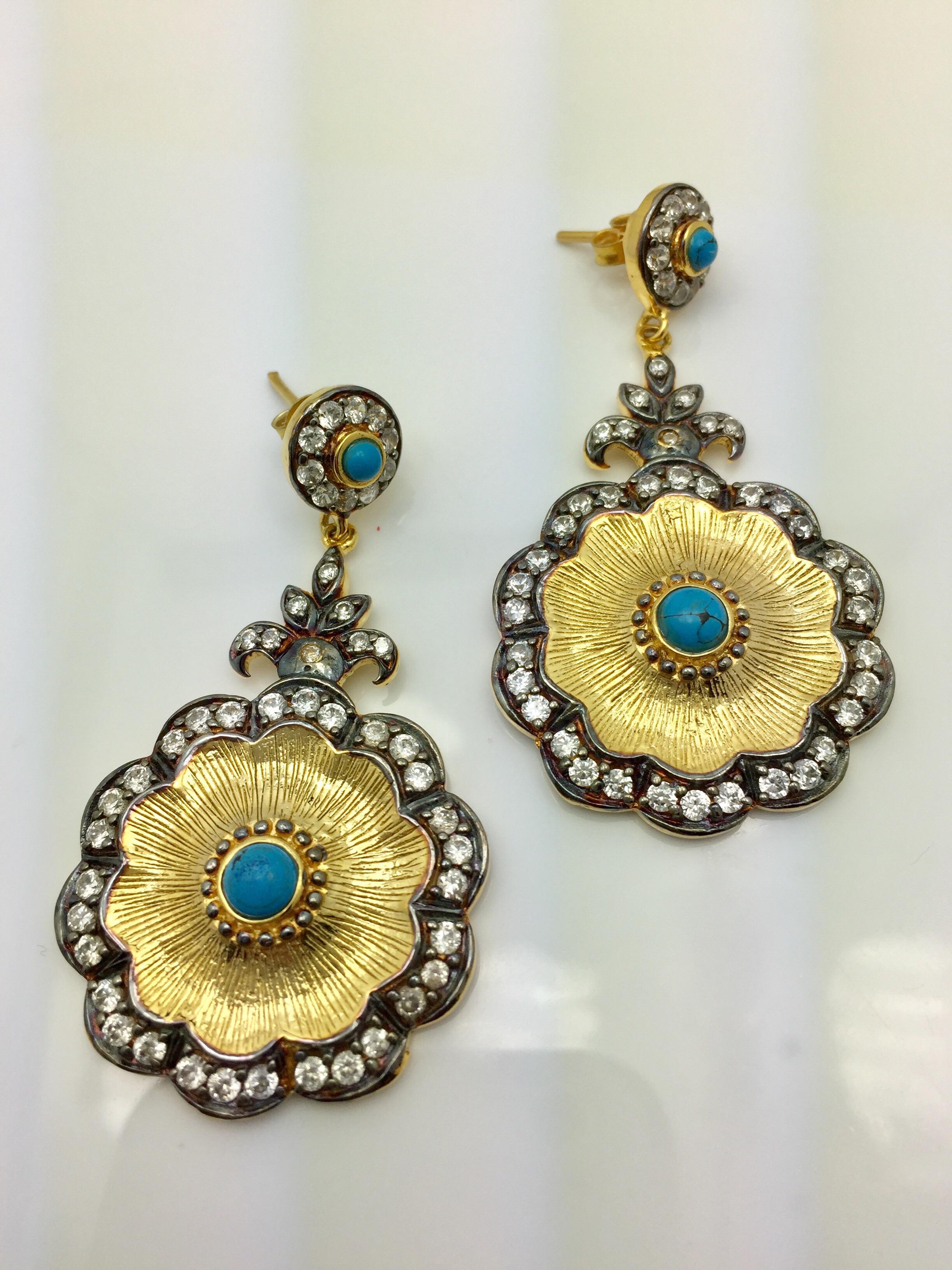 Two-tones: silver and gold, coexist in harmony, enhanced by dozens of twinkling CZ stones in flower shaped turquoise and CZ drop earrings. These earrings hit all the trends in an elegantly beautiful way. Earrings have a post closure for pierced