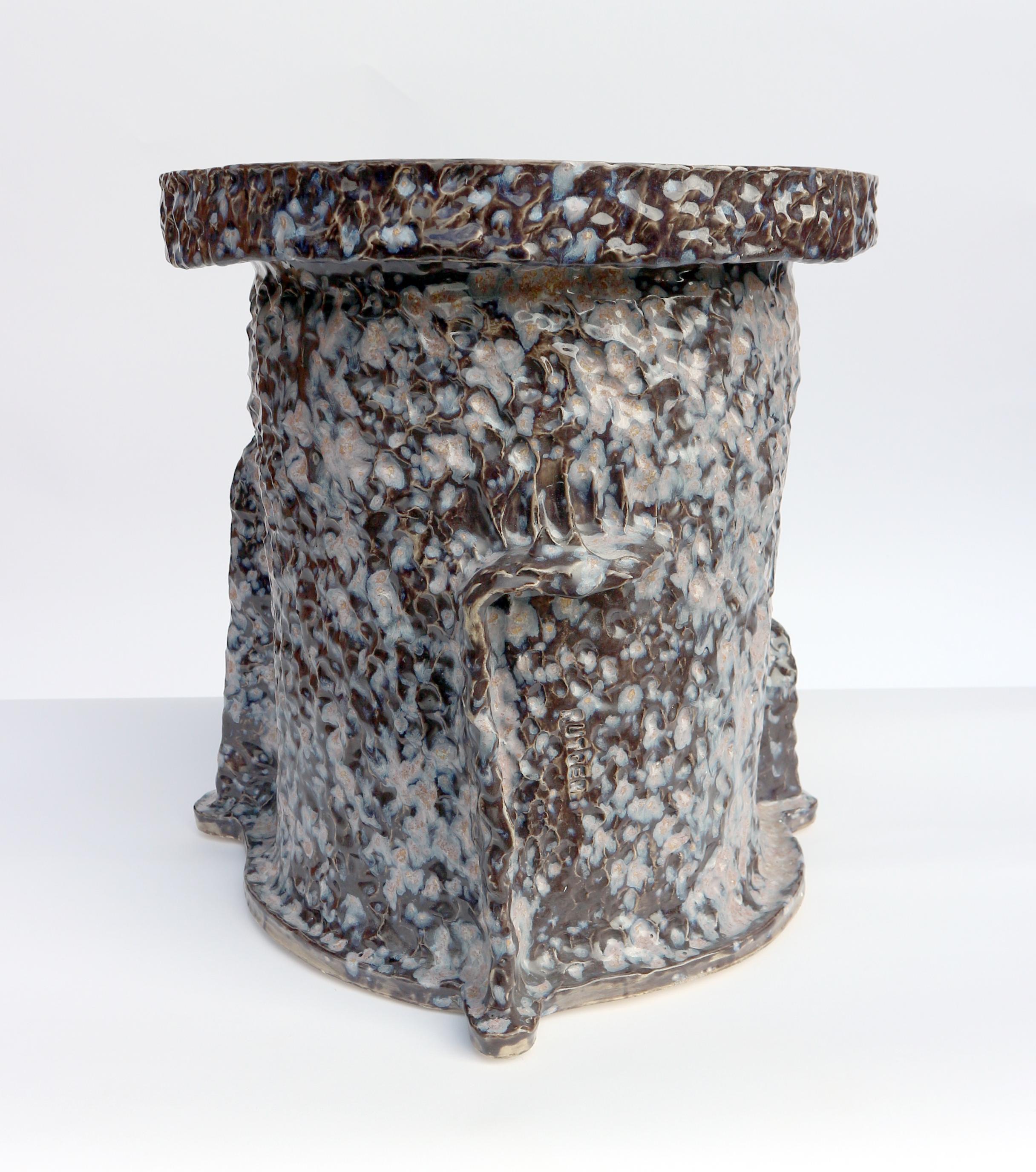 Hand-build stoneware side table, leaving fingerprints of the artist to emphasise on the handmade character. 

The piece is a one-off and signed by the artist.

The stoneware side table can be used outside and has a bold  black glaze with purple