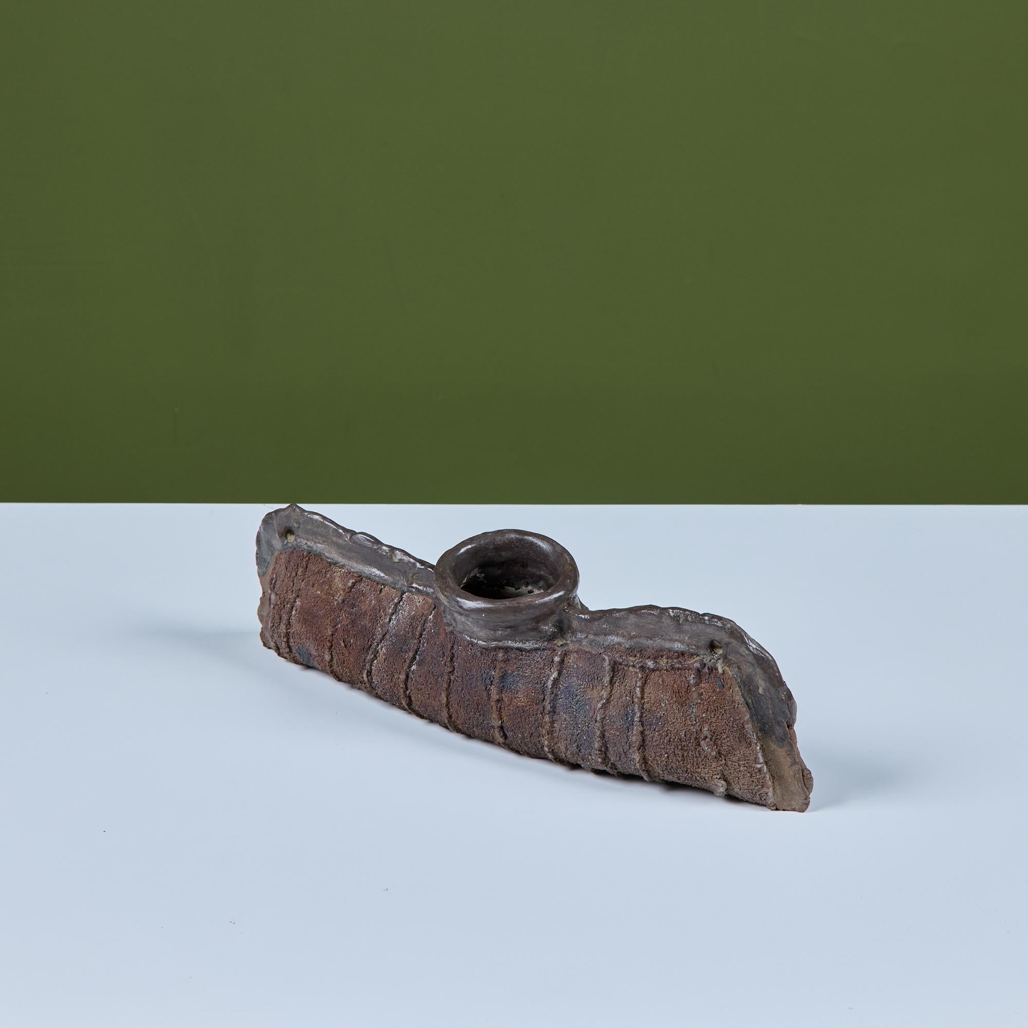 Horizontal ceramic vase by Japanese American artist, Takao Tomono, c.1973, USA. The vase features a long body with circular center opening at the top and pinched edges and linear designs throughout.  Please note, this piece can not hold