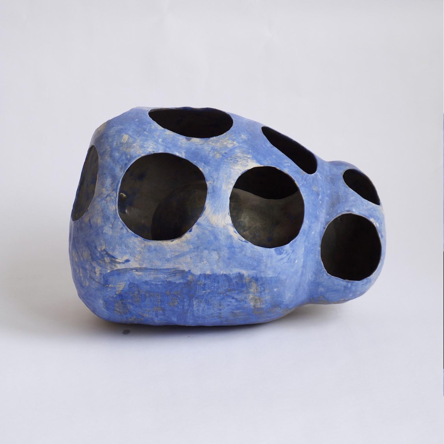 Blue Sheep is a contemporary hand-built stoneware ceramic sculpture with cutouts revealing the double-layered internal structure. This piece is finished in a cobalt oxide glaze, creating the characteristic blue and purple hues. It is entirely